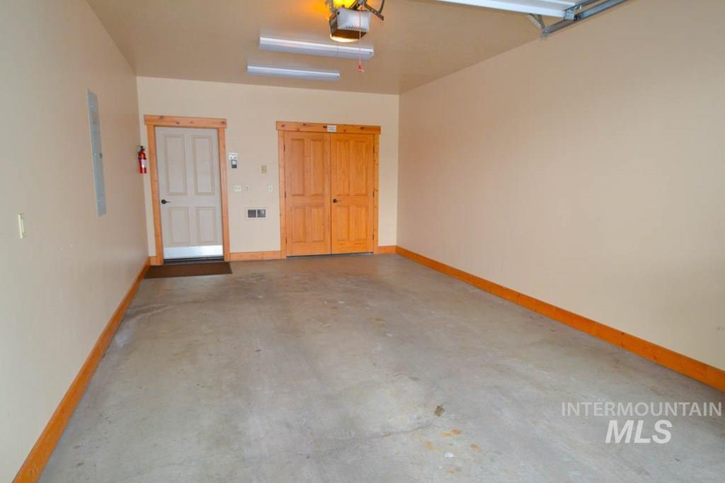 Garage featuring a garage door opener and electric panel