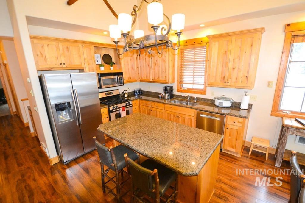 Kitchen featuring appliances with stainless steel finishes, light brown cabinetry, decorative light fixtures, and recessed lighting