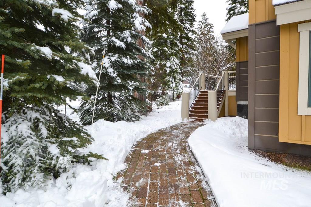 Yard covered in snow with stairway and a deck