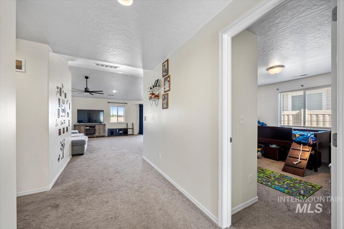 Corridor featuring carpet and a textured ceiling
