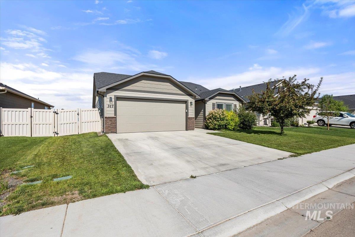 Single story home with a gate, an attached garage, concrete driveway, and brick siding