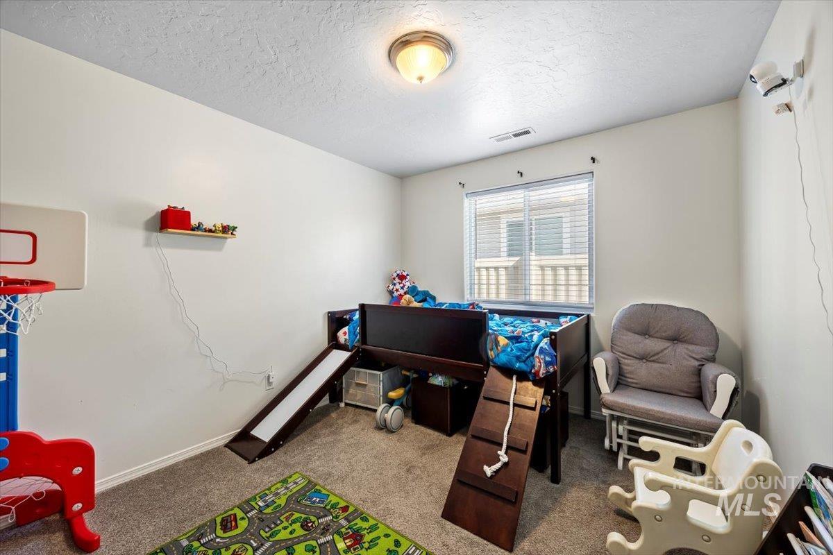 Bedroom with carpet floors and a textured ceiling