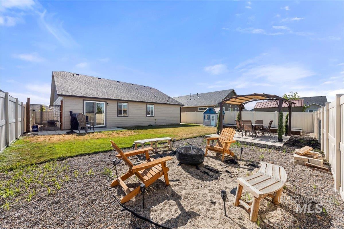 Back of property featuring a fire pit, a gazebo, a patio area, and a fenced backyard