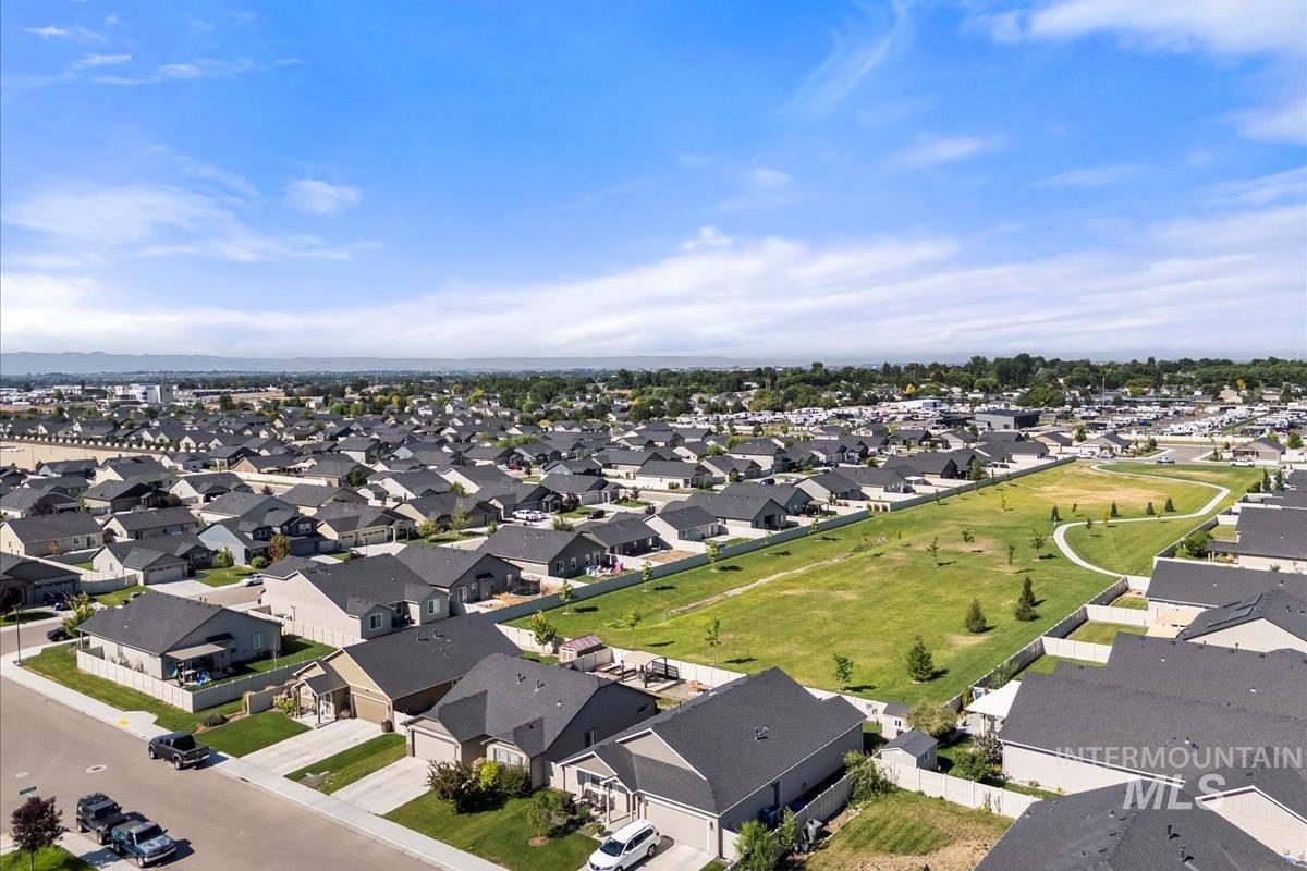 Aerial view of property and surrounding area featuring nearby suburban area