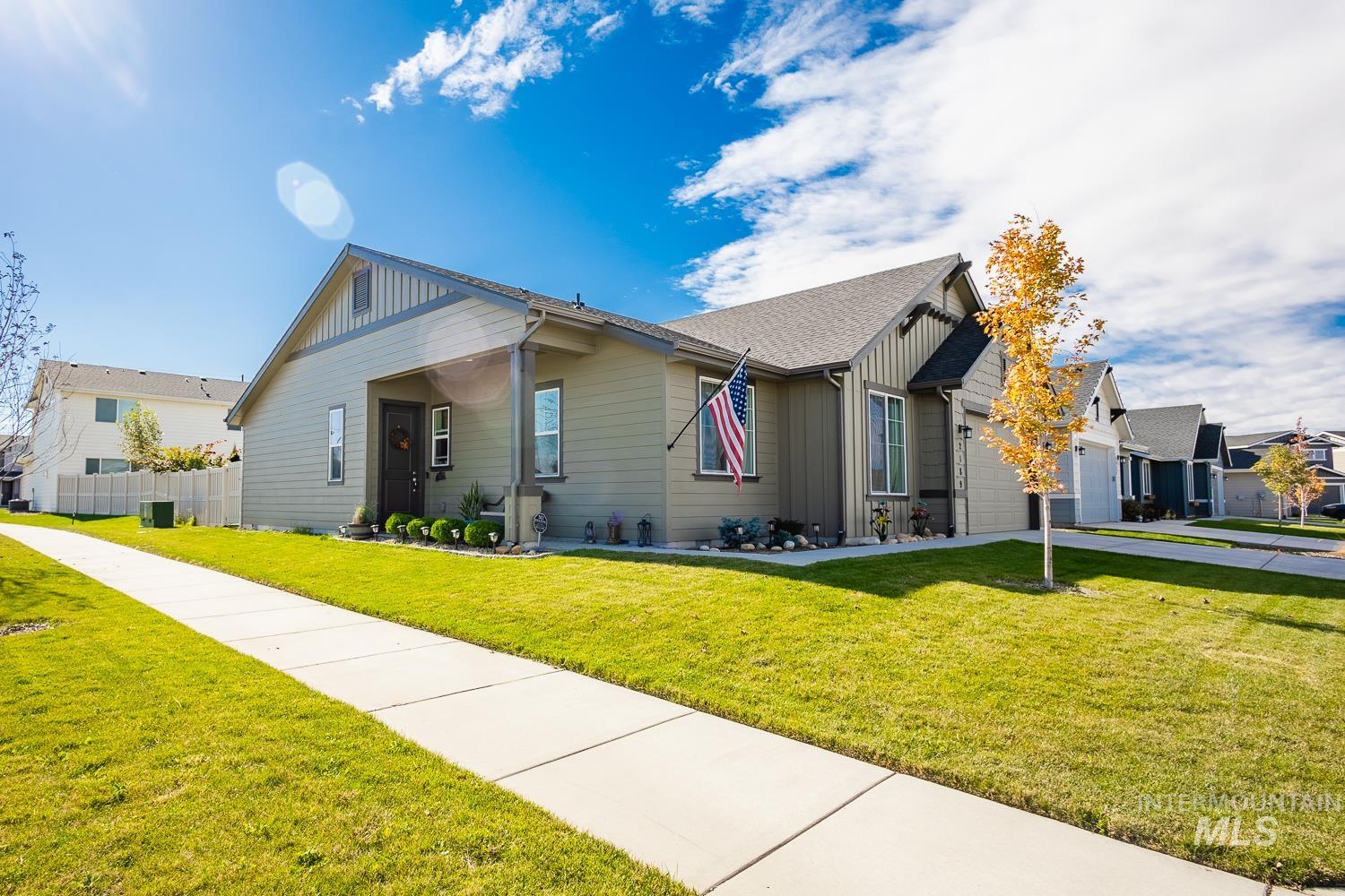 Craftsman-style home featuring board and batten siding, an attached garage, and roof with shingles