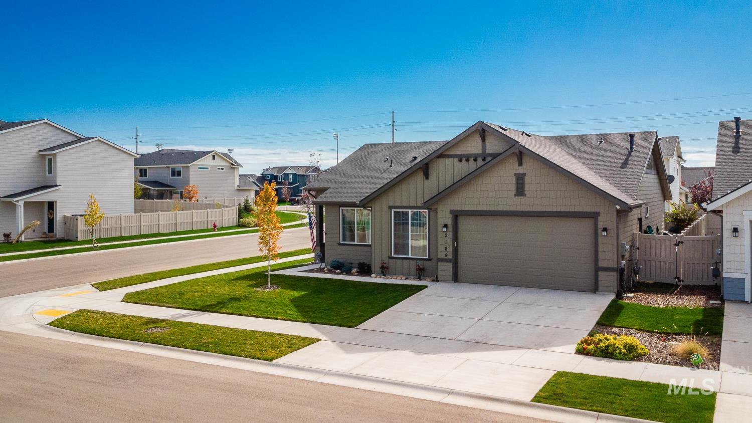 View of front of home with a residential view, concrete driveway, a garage, a gate, and roof with shingles