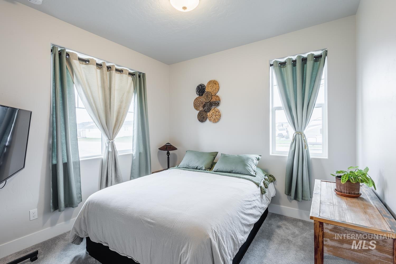 Bedroom featuring dark carpet and multiple windows