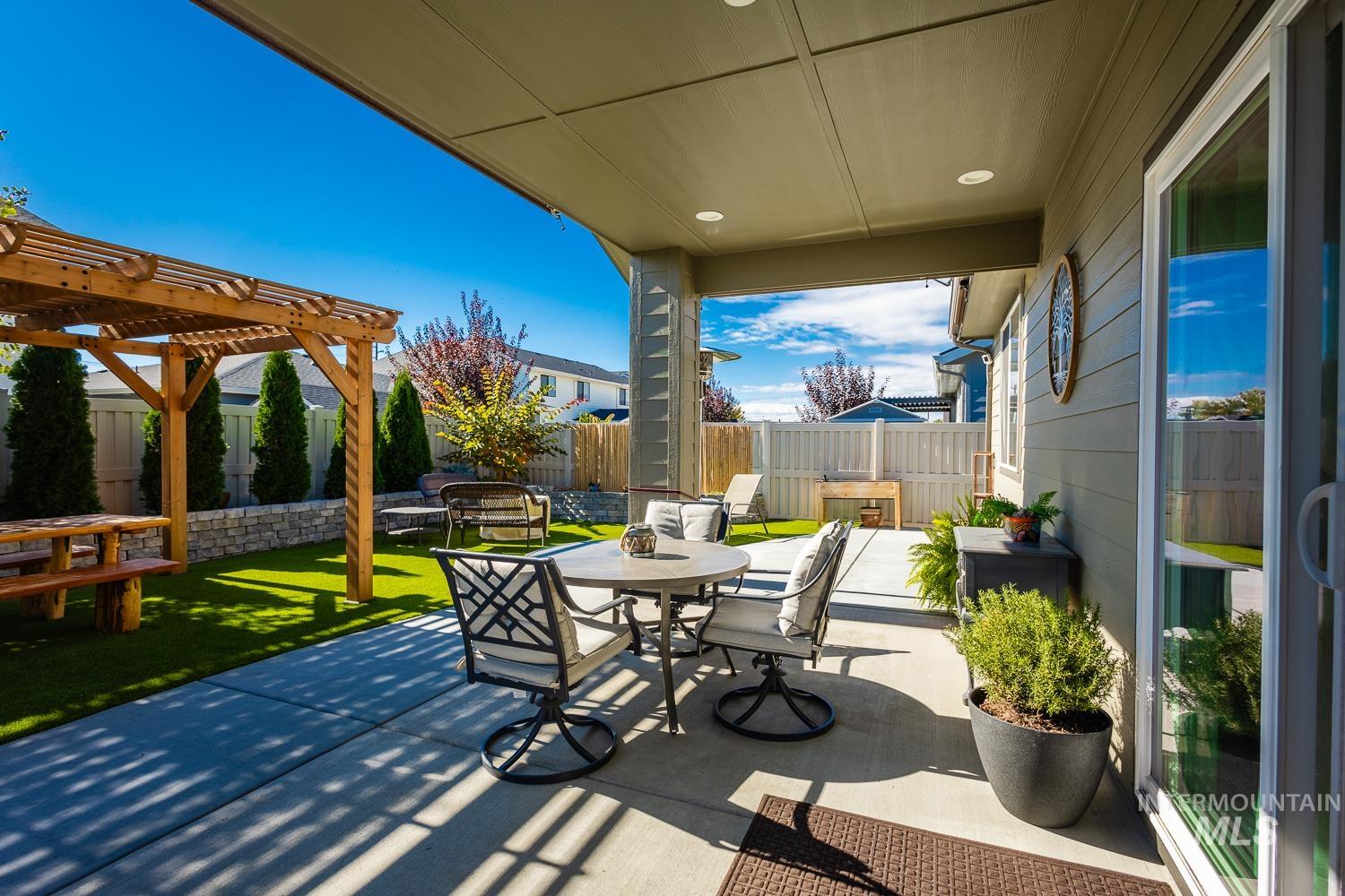 Fenced backyard with a patio, outdoor dining space, and a pergola