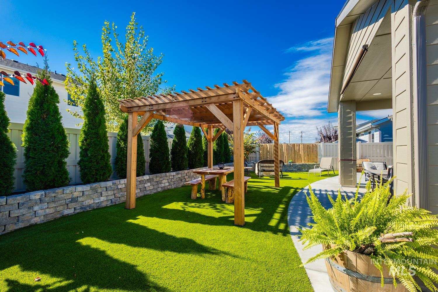 Fenced backyard featuring a pergola and a patio area