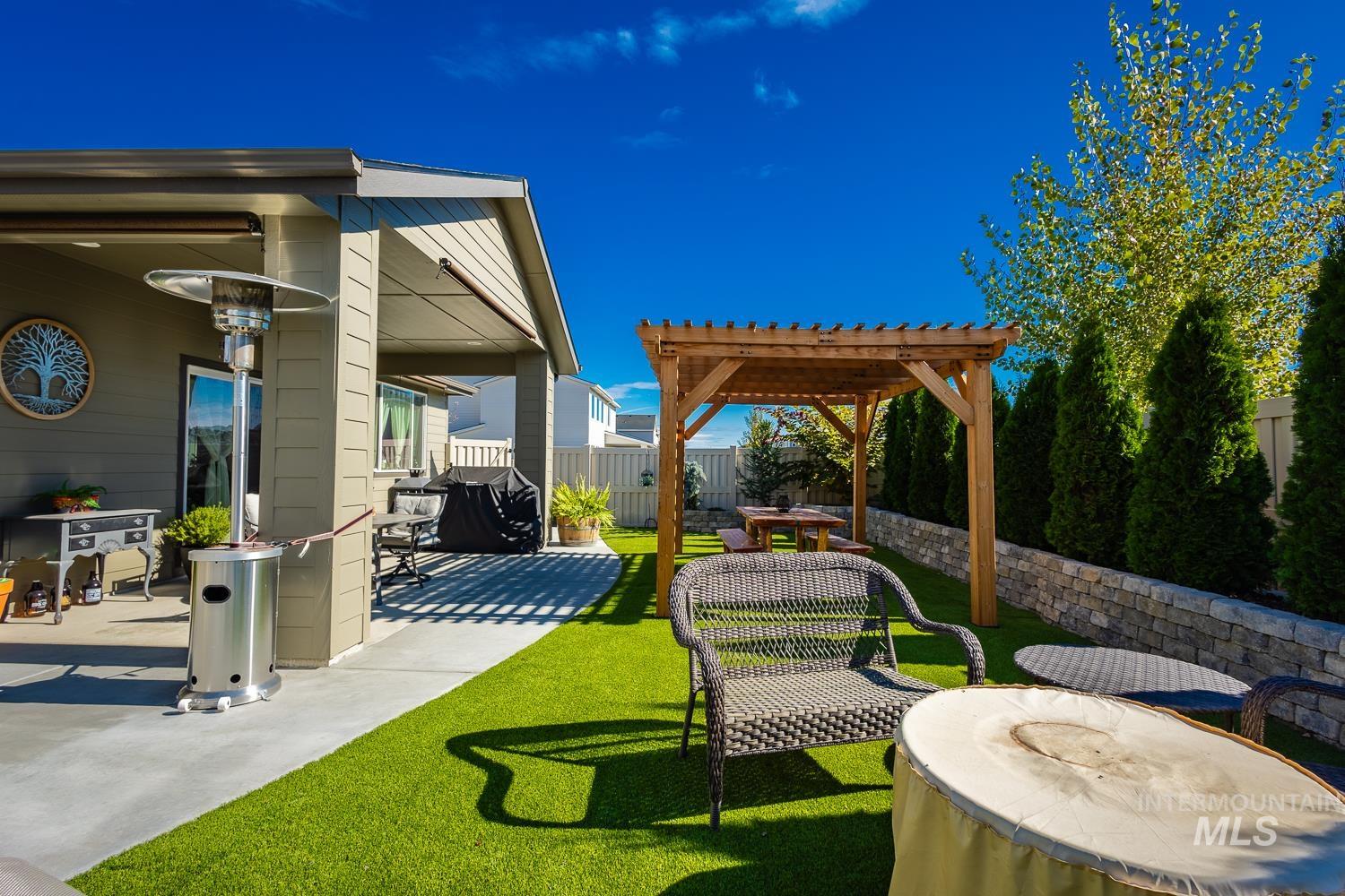 Fenced backyard featuring a patio and a pergola
