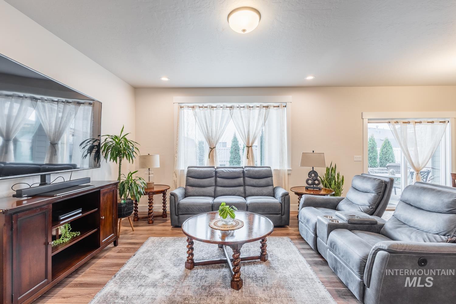 Living area featuring light wood finished floors, plenty of natural light, and recessed lighting