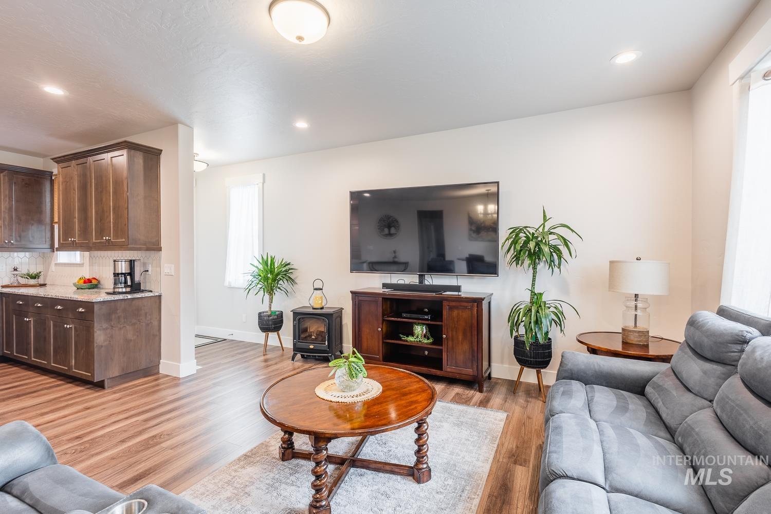 Living area featuring light wood-style floors, a wood stove, and recessed lighting