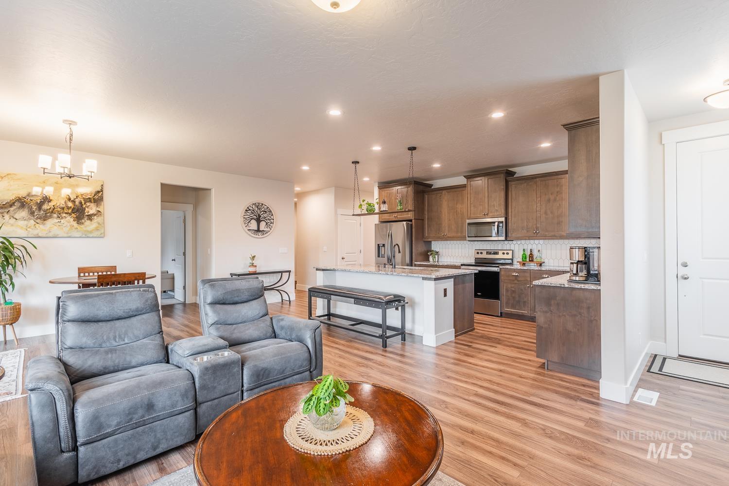 Living room with a chandelier, recessed lighting, and light wood-style floors
