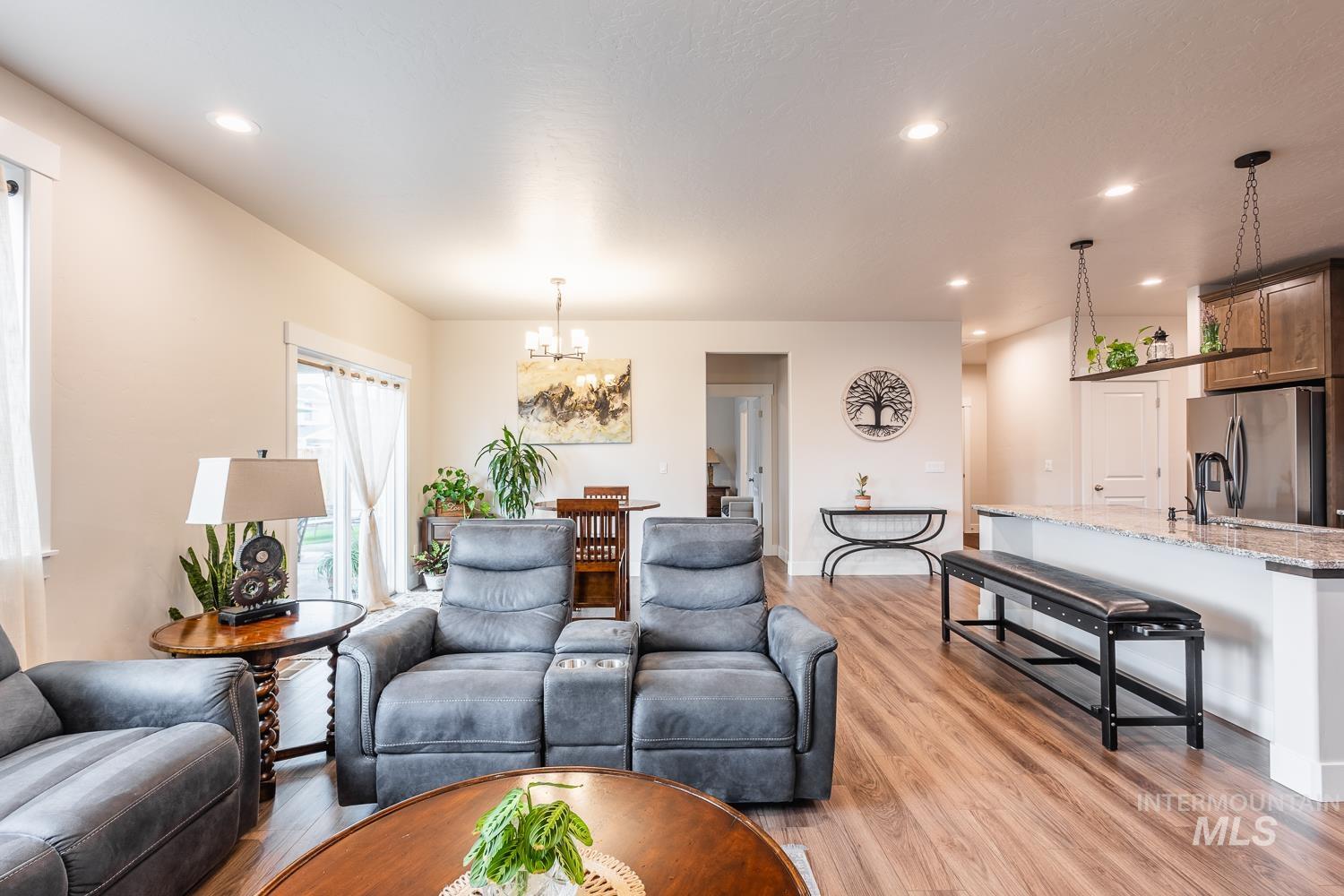 Living area with light wood-type flooring, recessed lighting, and a chandelier