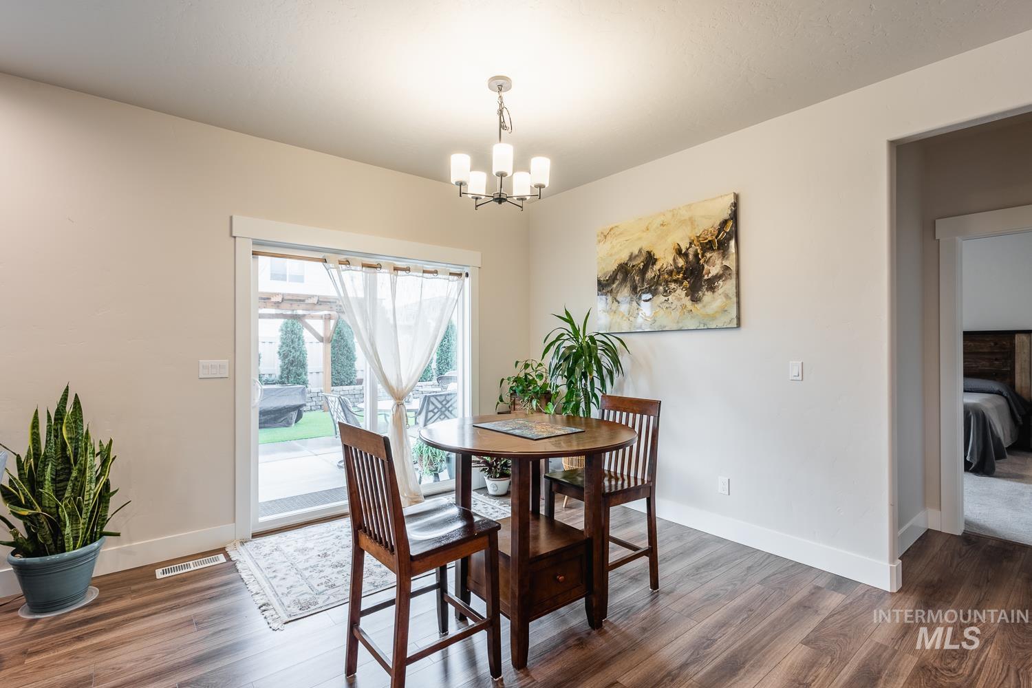 Dining area with wood finished floors and a chandelier
