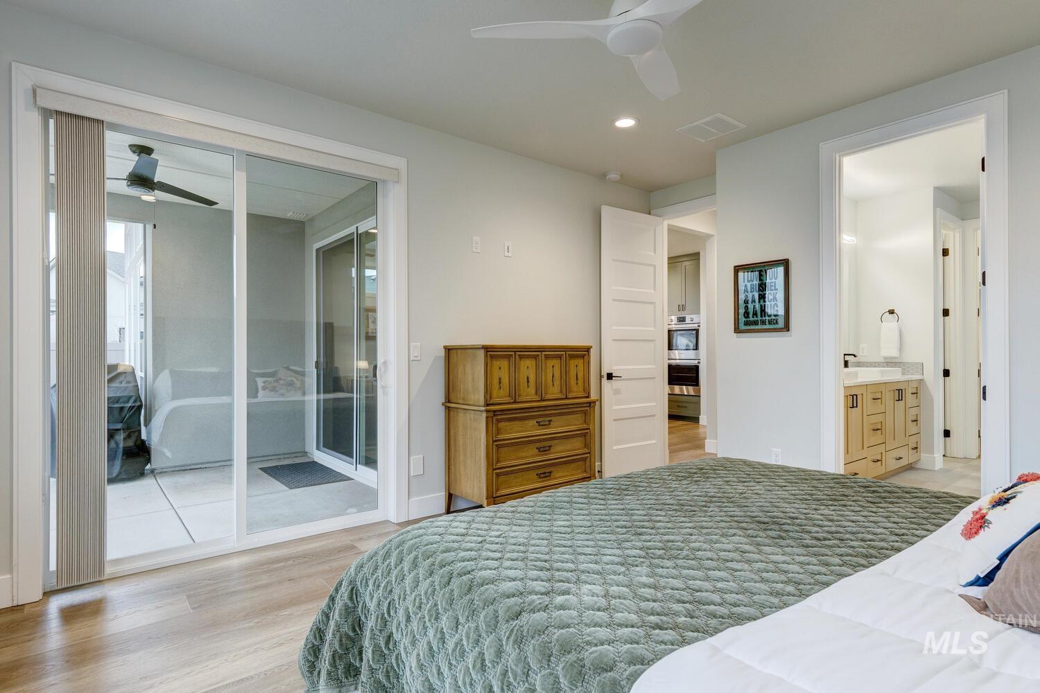 Bedroom with light wood-style floors, ceiling fan, recessed lighting, access to exterior, and ensuite bath