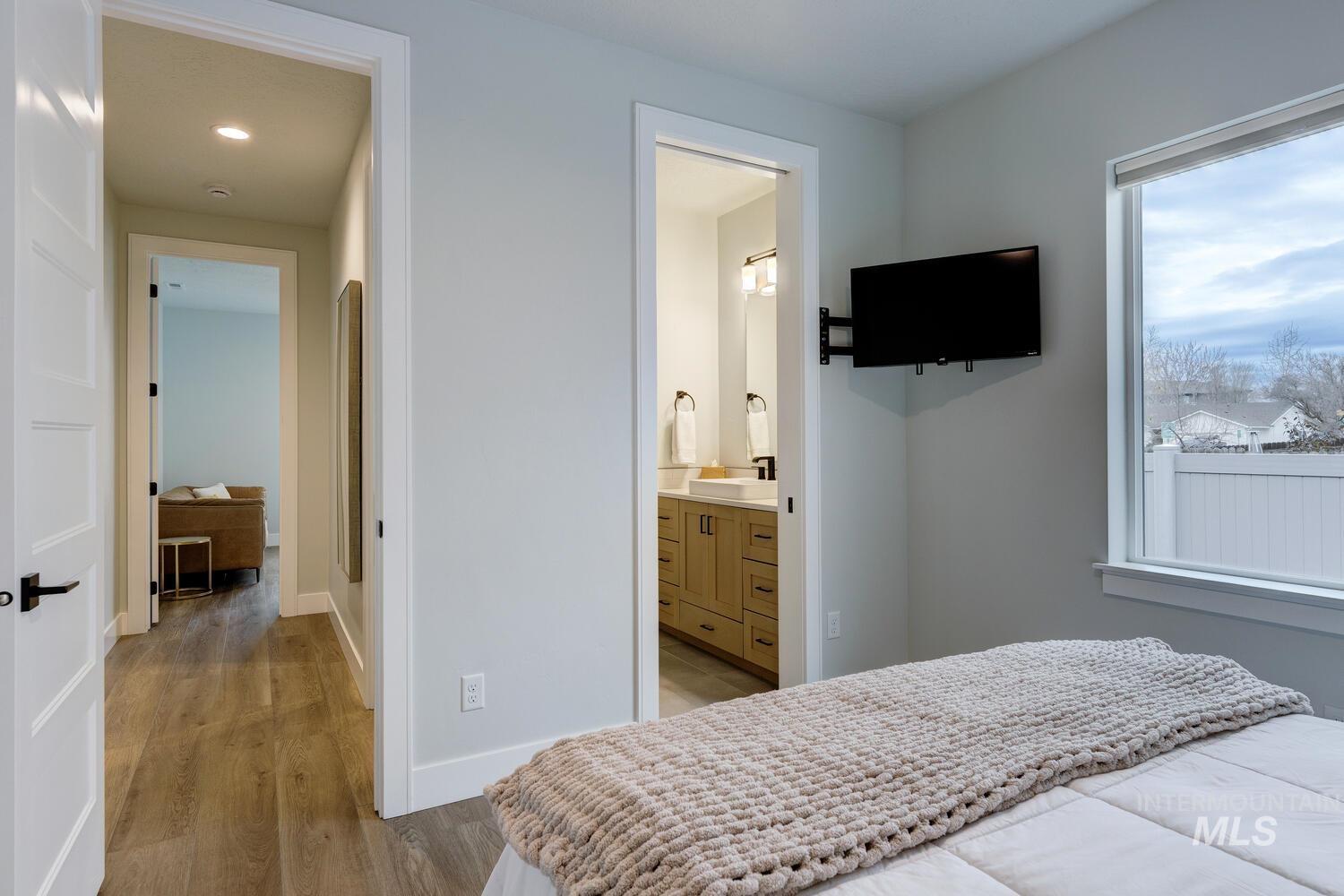 Bedroom featuring light wood-style flooring and ensuite bathroom