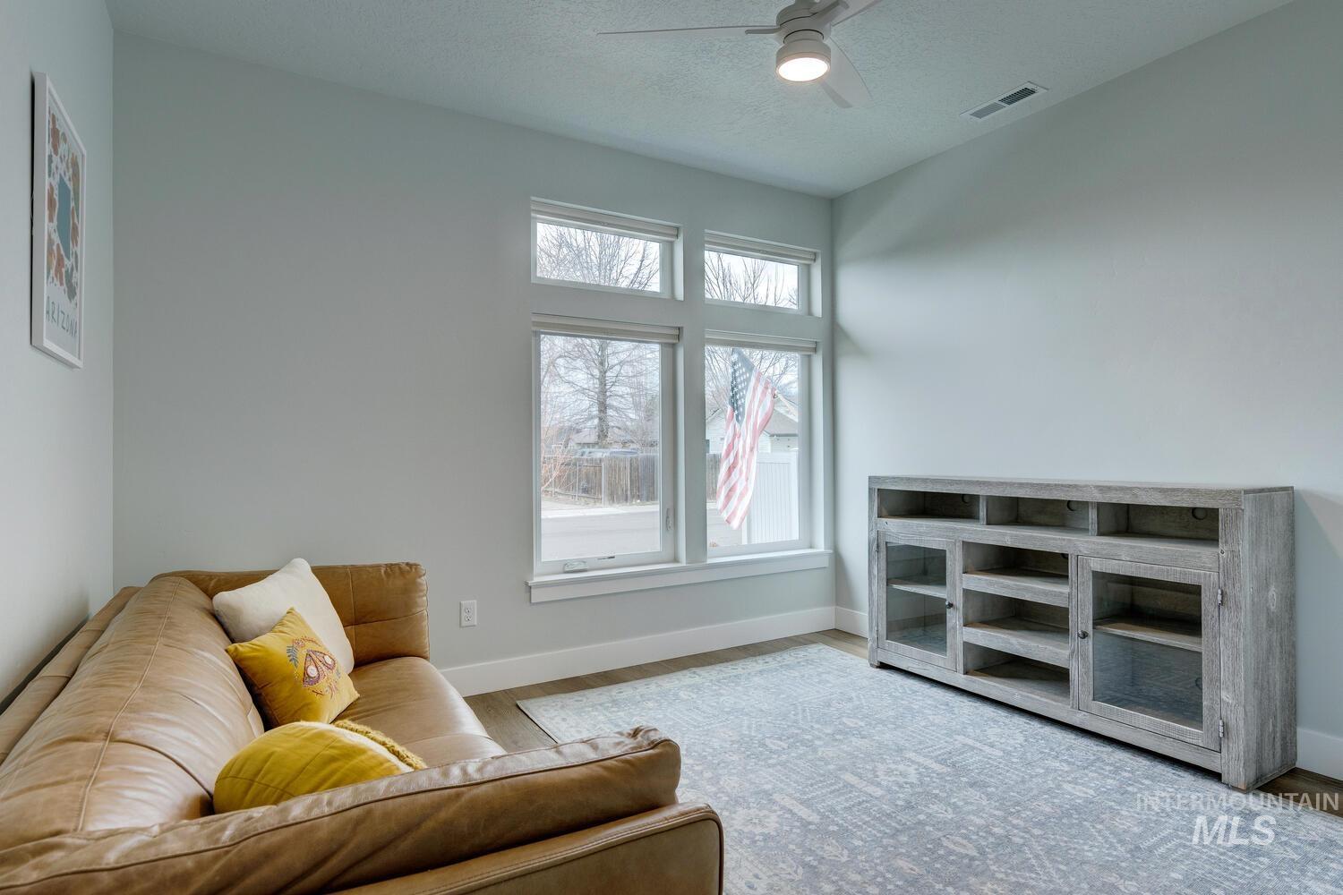 Sitting room featuring a textured ceiling, ceiling fan, and wood finished floors