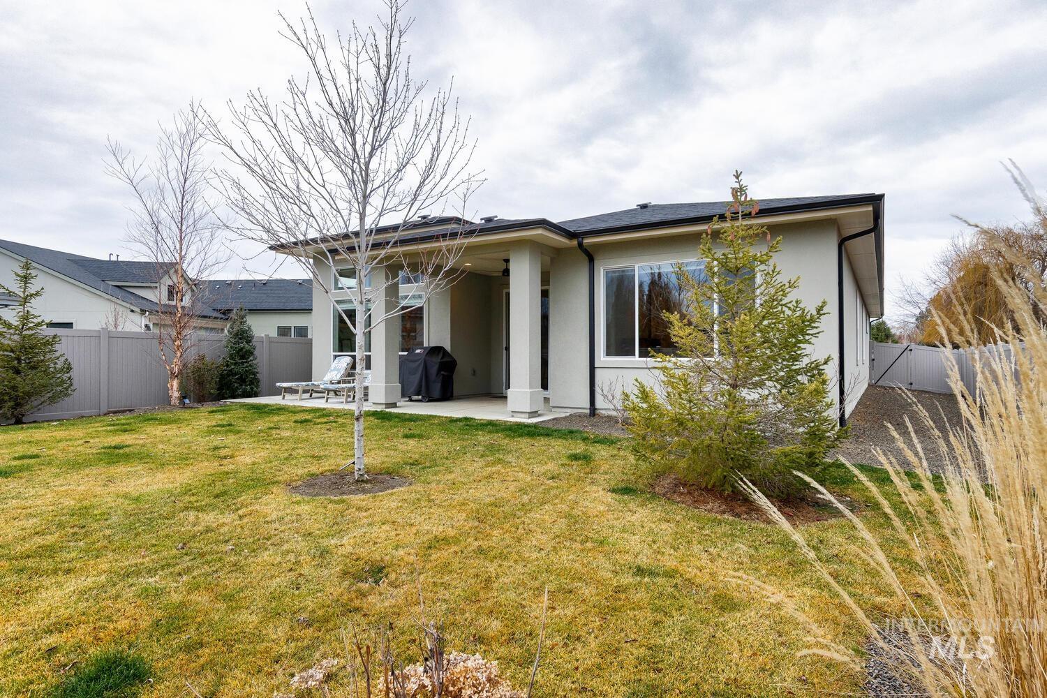 Rear view of property with a fenced backyard, a patio area, and stucco siding