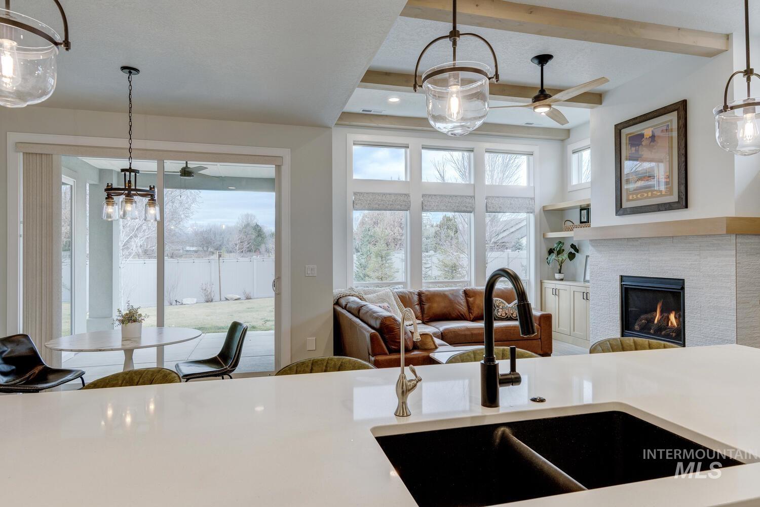 Kitchen featuring hanging light fixtures, open floor plan, a ceiling fan, beamed ceiling, and recessed lighting