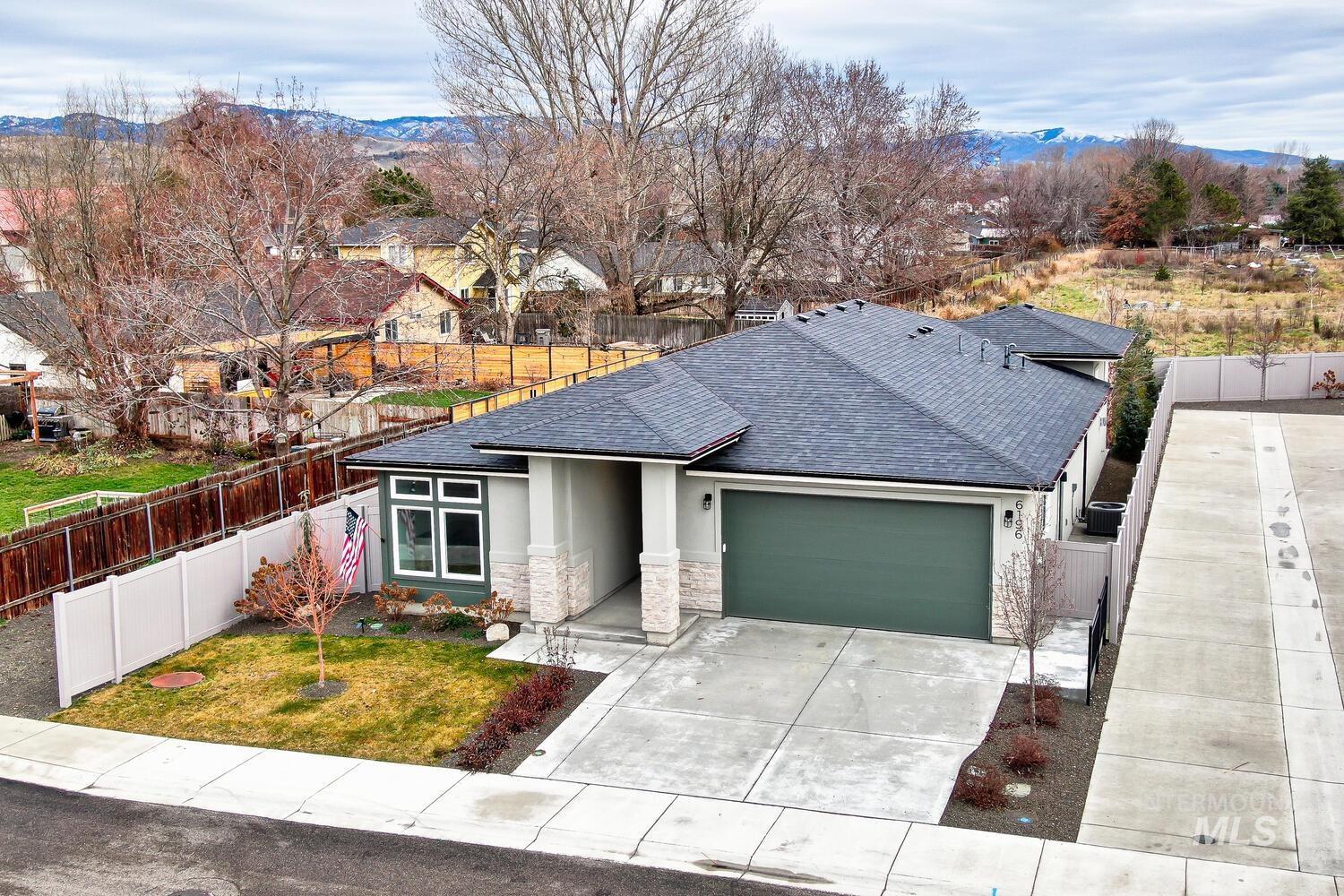 View of front facade featuring stucco siding, a mountain view, an attached garage, concrete driveway, and a shingled roof