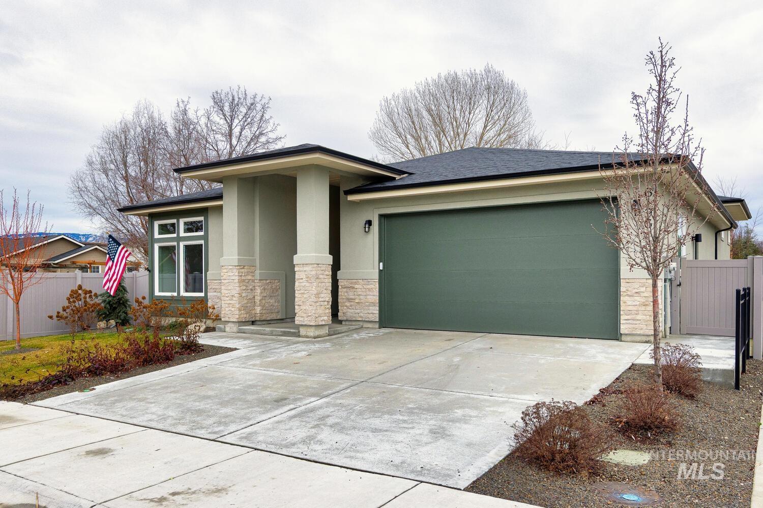 Prairie-style house featuring stone siding, stucco siding, concrete driveway, and a garage