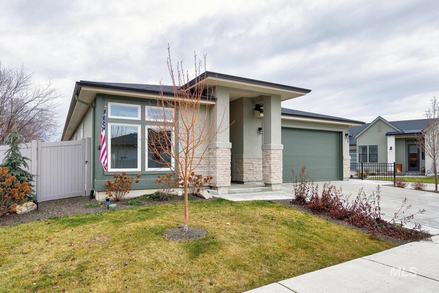 Prairie-style home with driveway, stucco siding, stone siding, and a garage