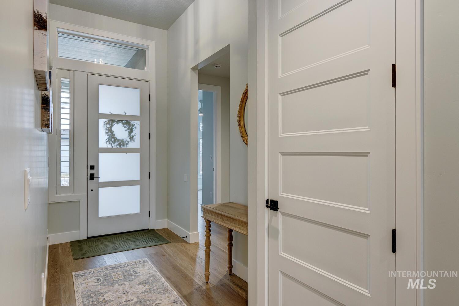 Foyer entrance with light wood-style floors and baseboards
