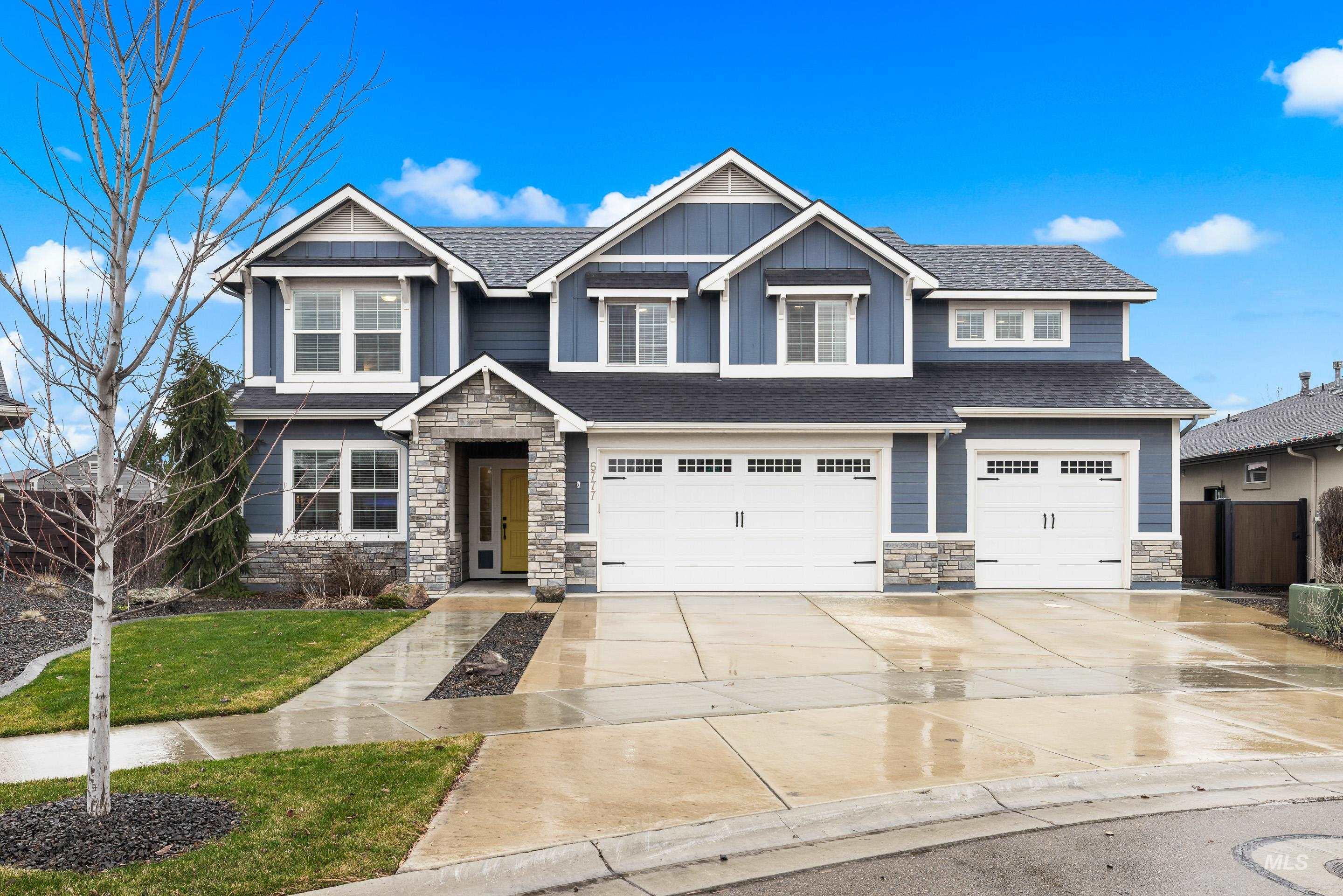 Craftsman-style home featuring stone siding, an attached garage, driveway, a front yard, and roof with shingles