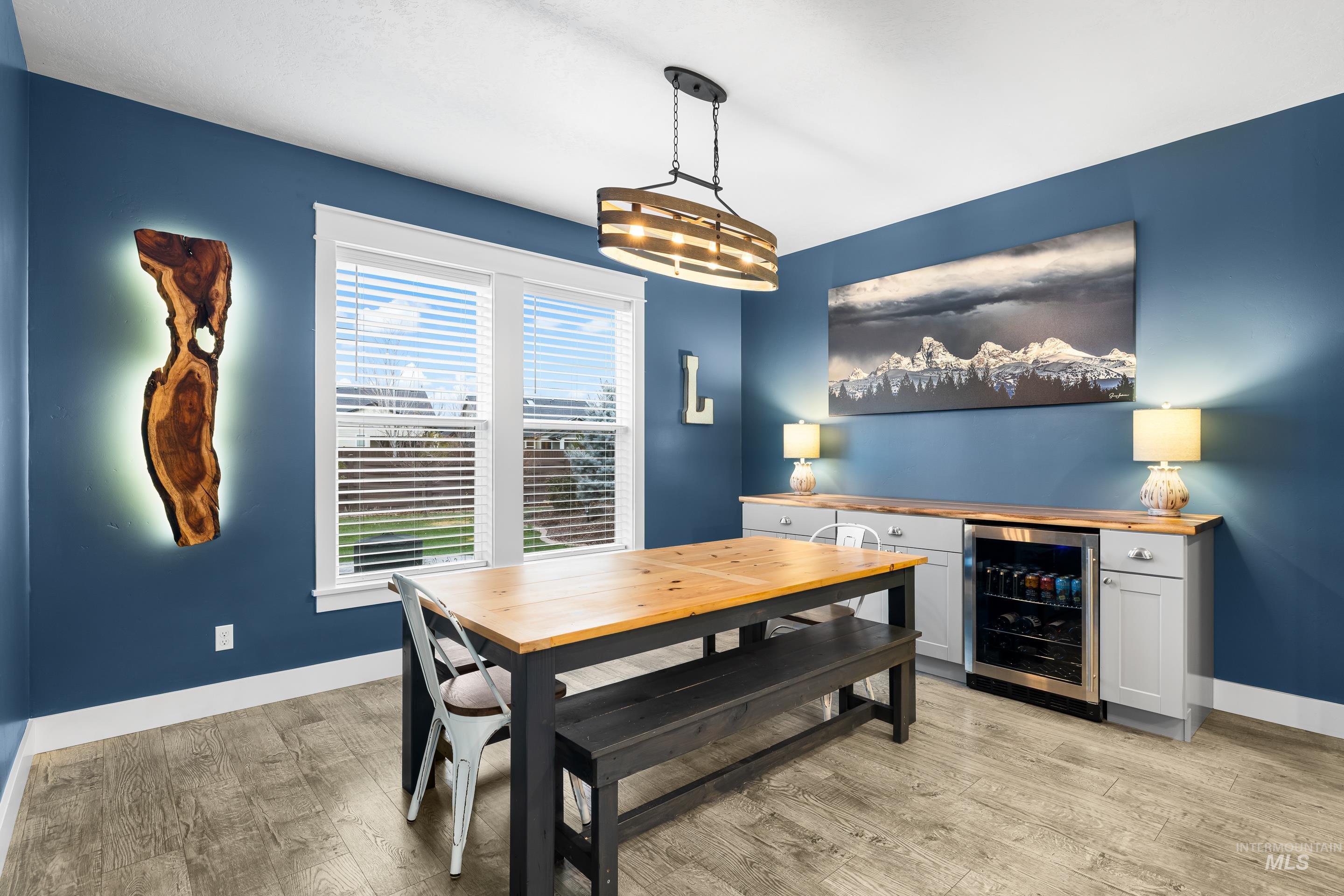 Dining space with wine cooler and light wood-style flooring