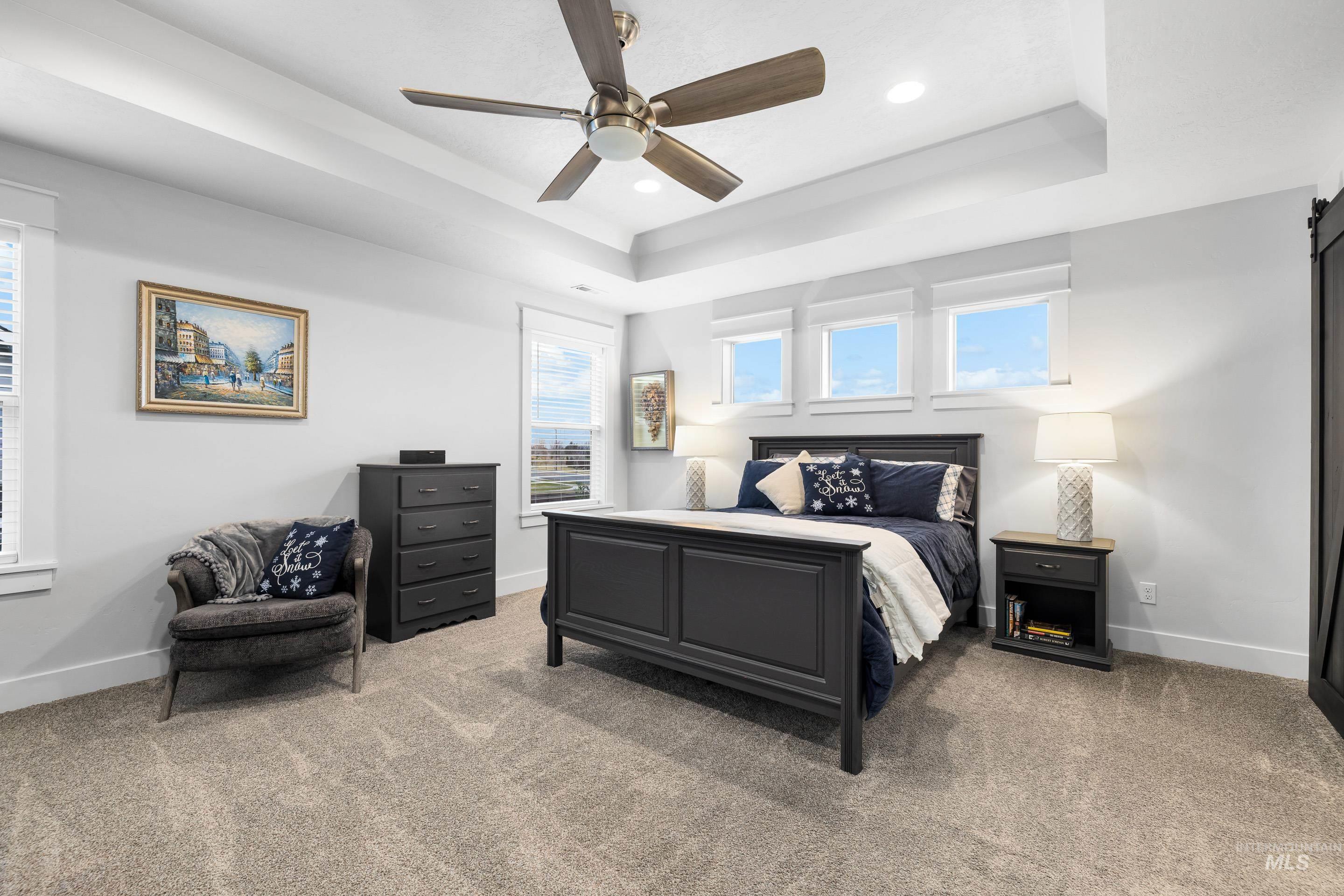 Bedroom featuring a raised ceiling, light carpet, ceiling fan, and recessed lighting