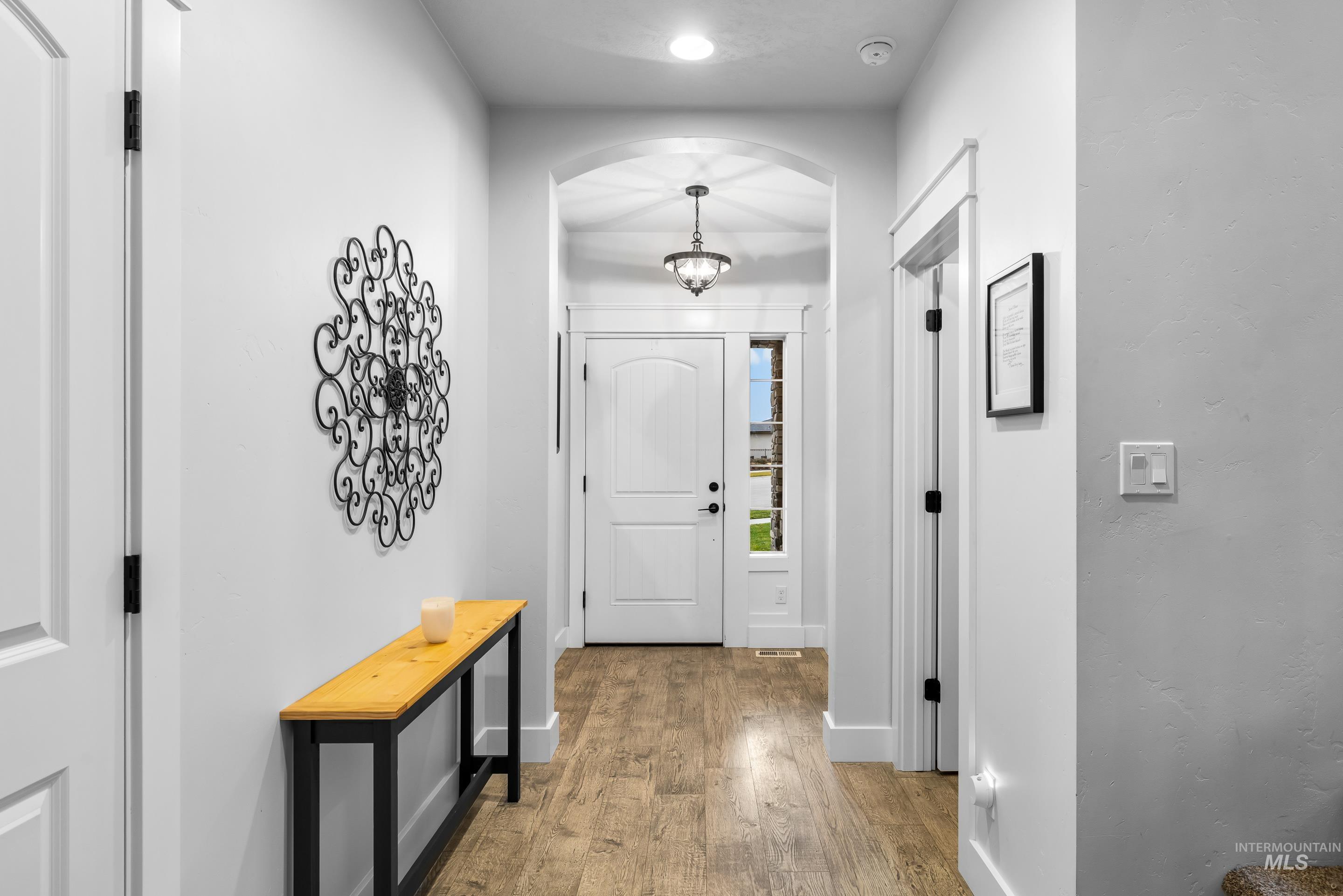 Doorway to outside featuring wood finished floors and arched walkways
