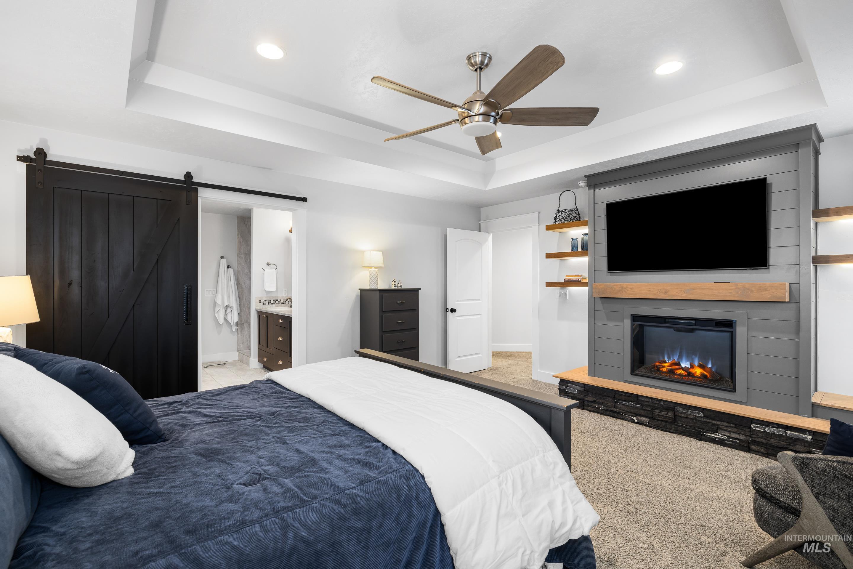 Bedroom with a tray ceiling, ceiling fan, light carpet, and recessed lighting