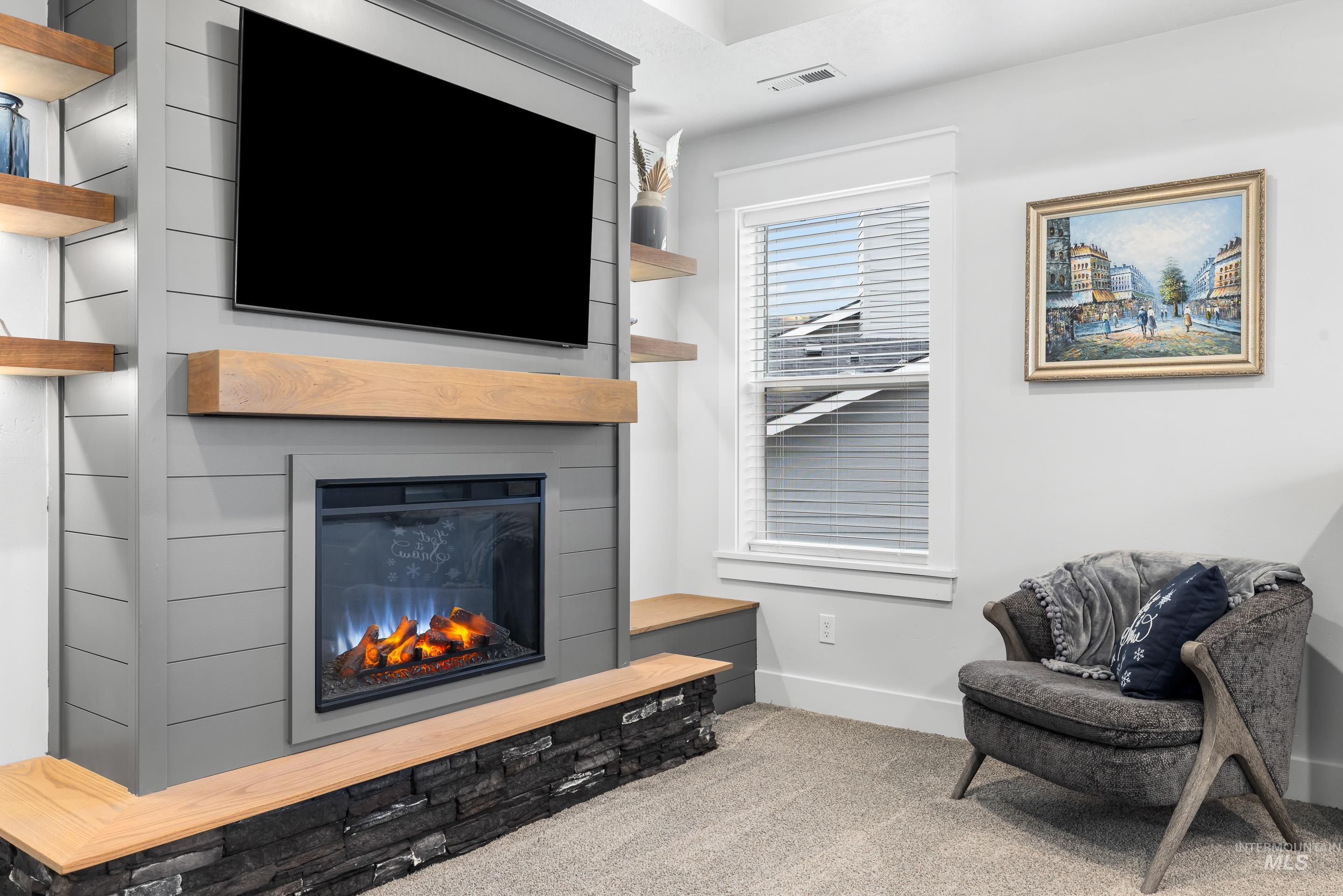Living room with carpet flooring and a large fireplace