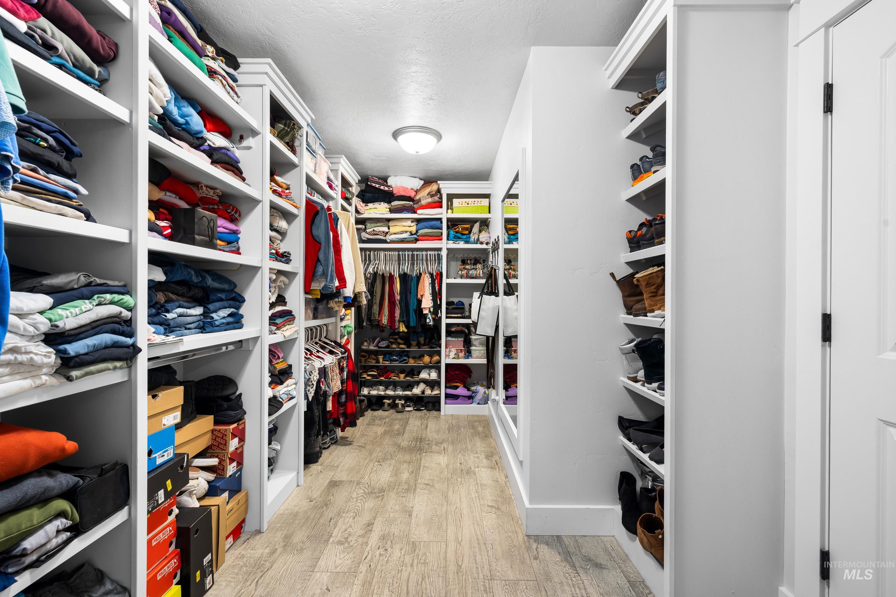 Walk in closet with light wood-type flooring