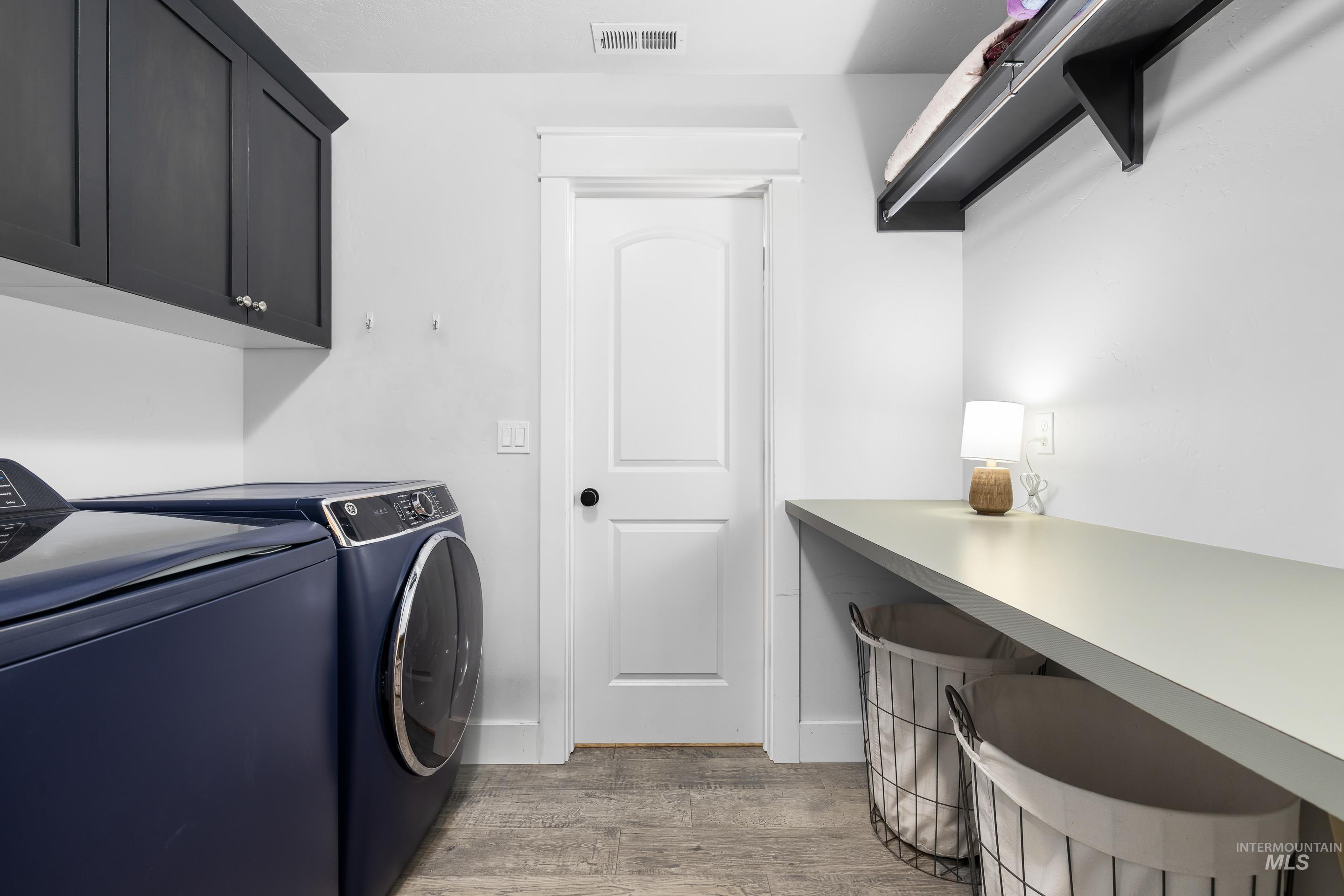 Washroom featuring washer and dryer and light wood-type flooring