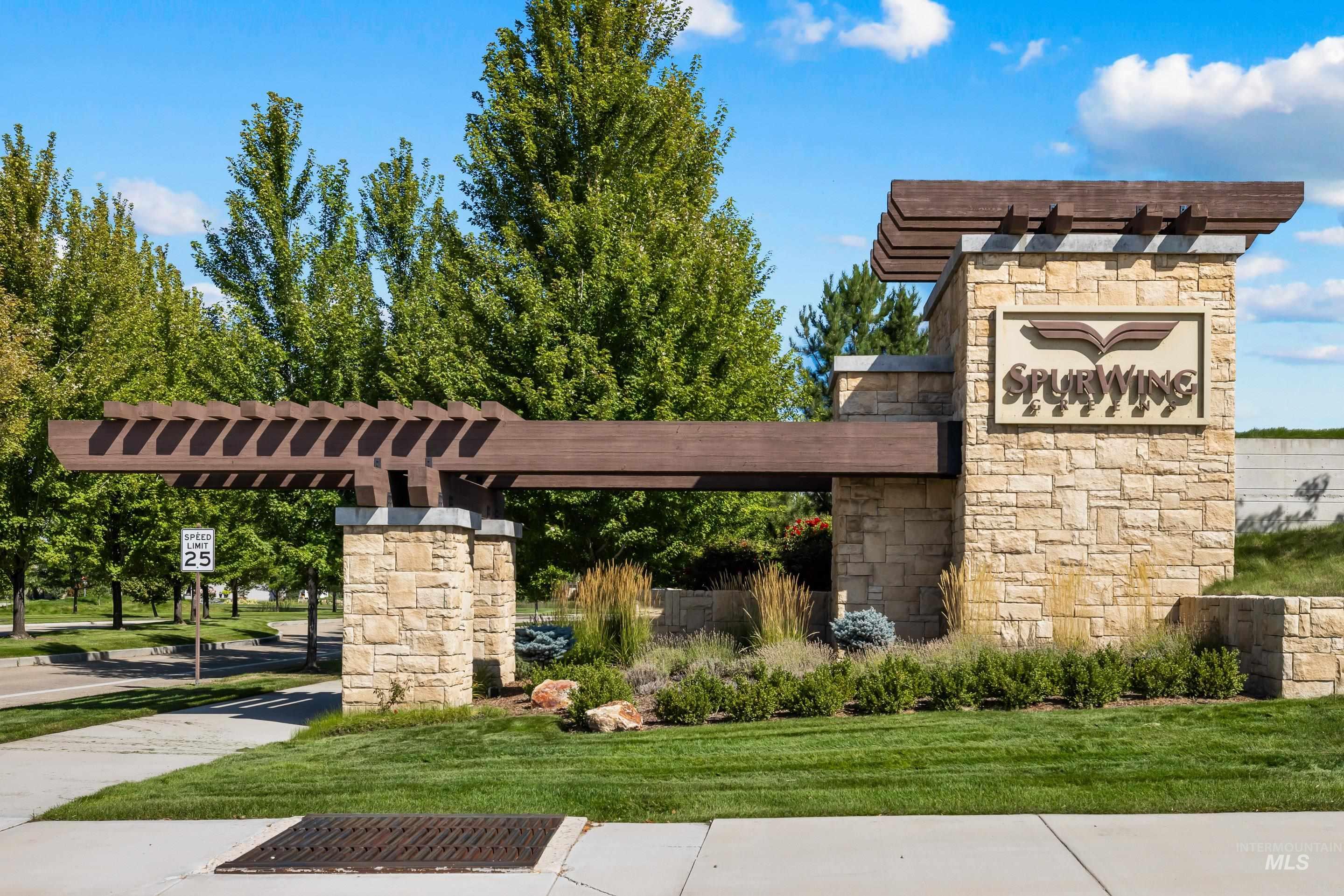Community / neighborhood sign featuring a lawn and a pergola
