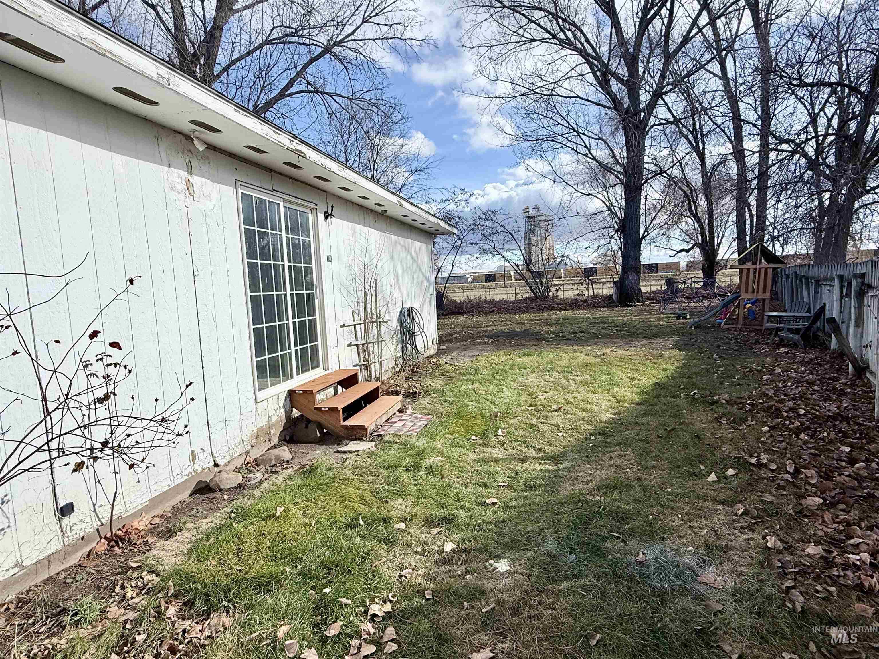 Fenced yard featuring a playground and entry steps
