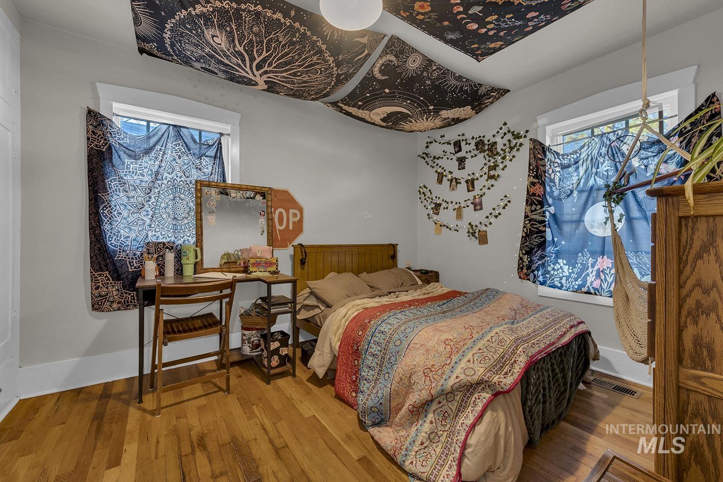 Bedroom with hardwood / wood-style flooring and multiple windows