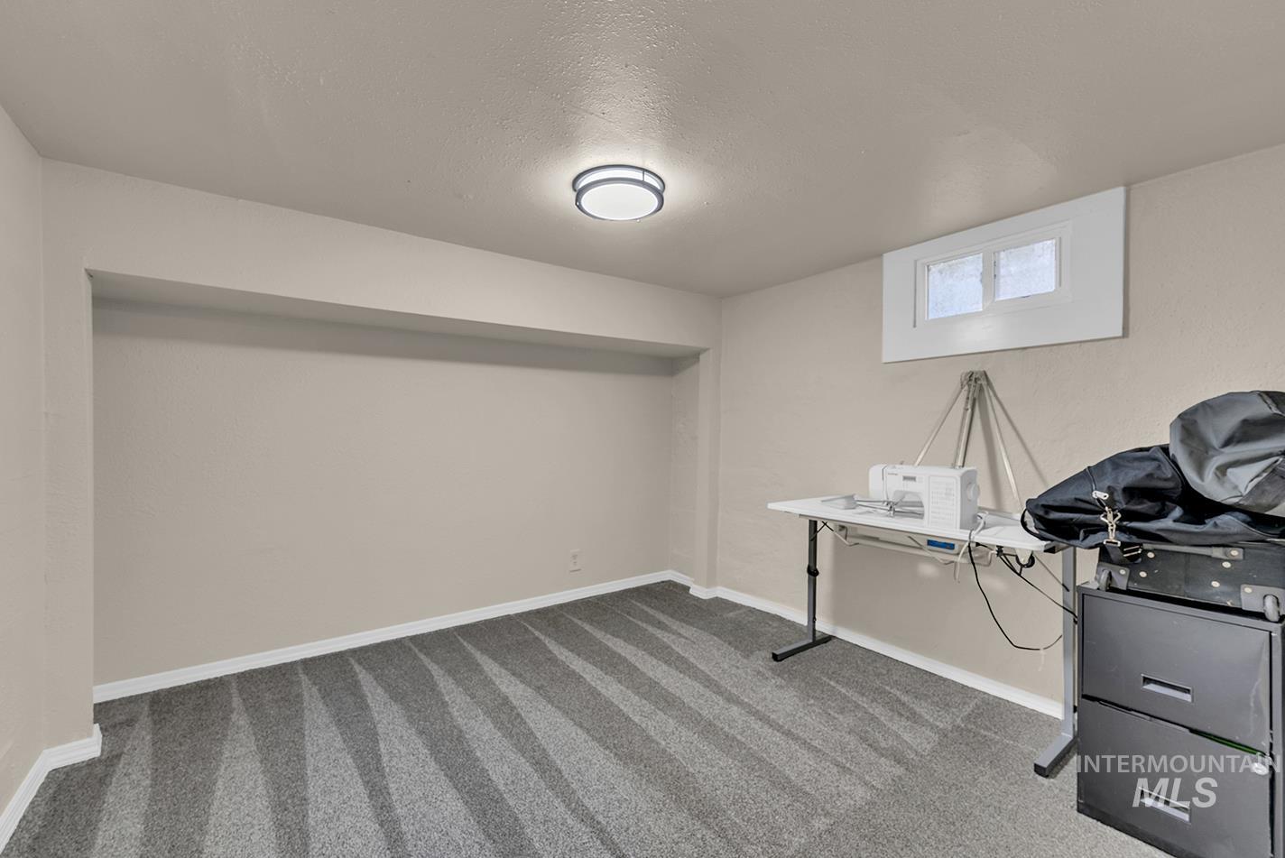 Office space with a textured ceiling and light colored carpet