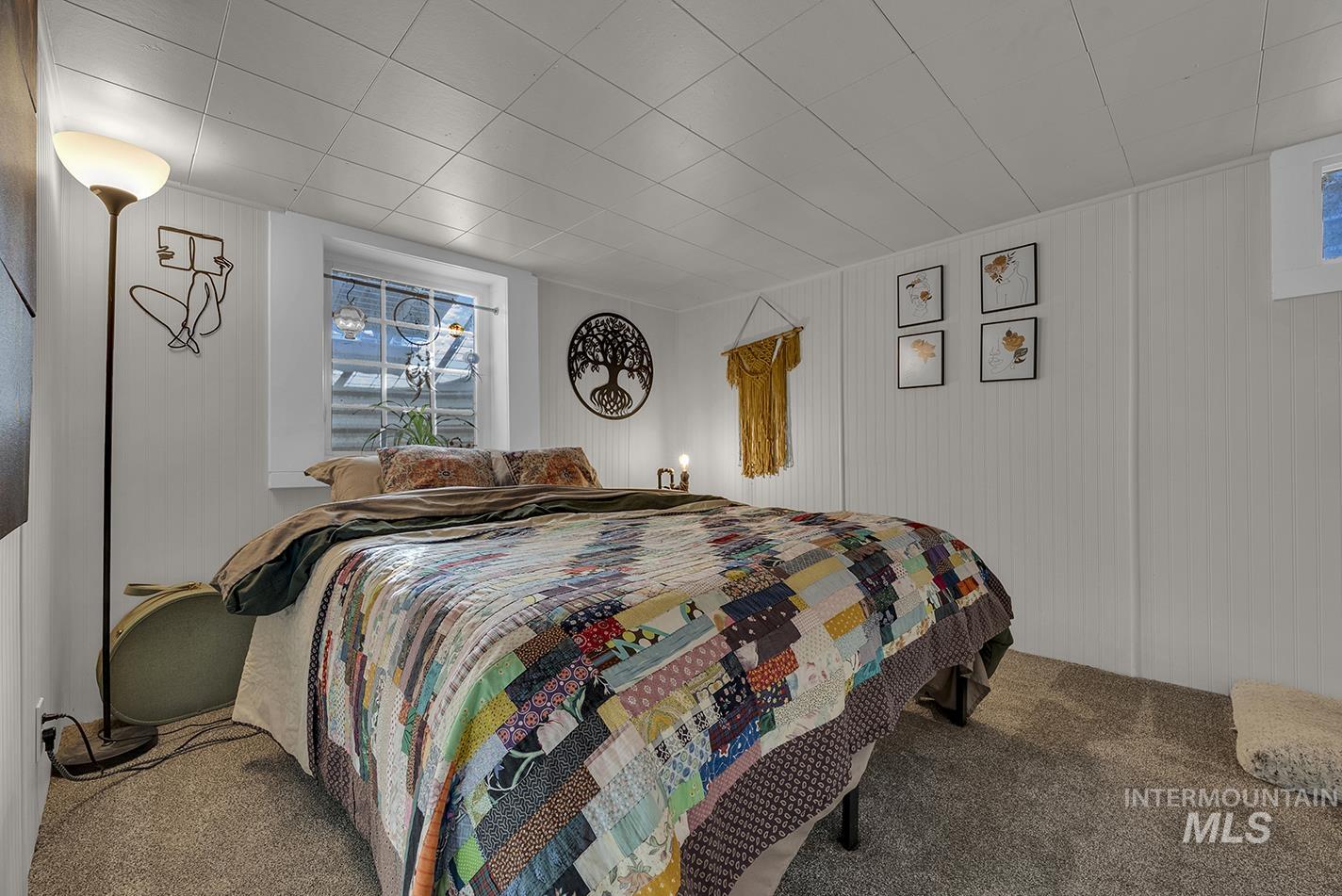 Carpeted bedroom with wooden walls