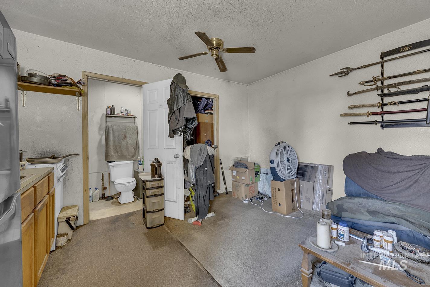Living area with ceiling fan and a textured ceiling
