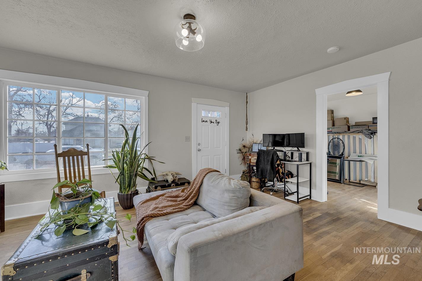 Living room with a textured ceiling and wood-type flooring