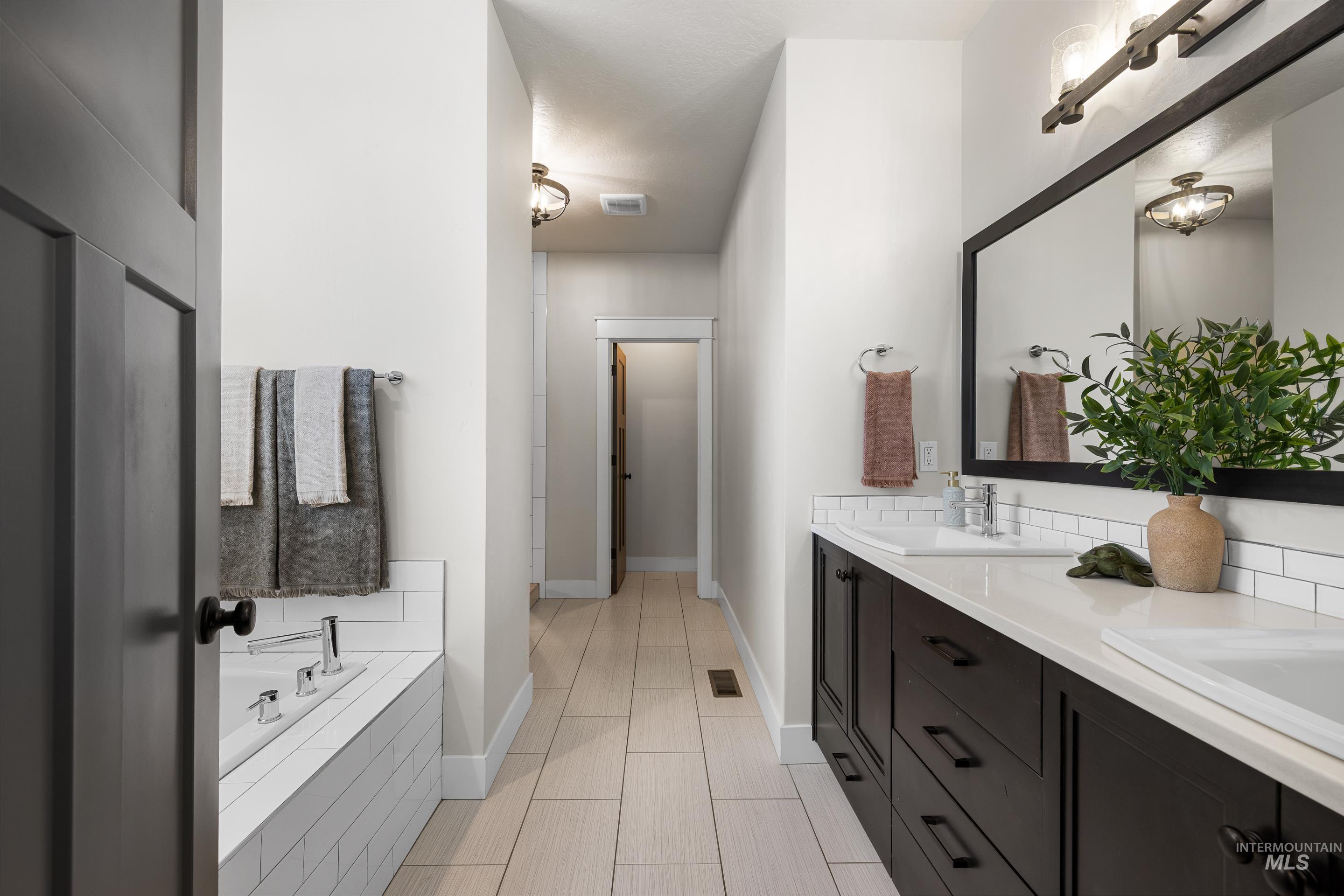 Full bathroom with double vanity and a bath