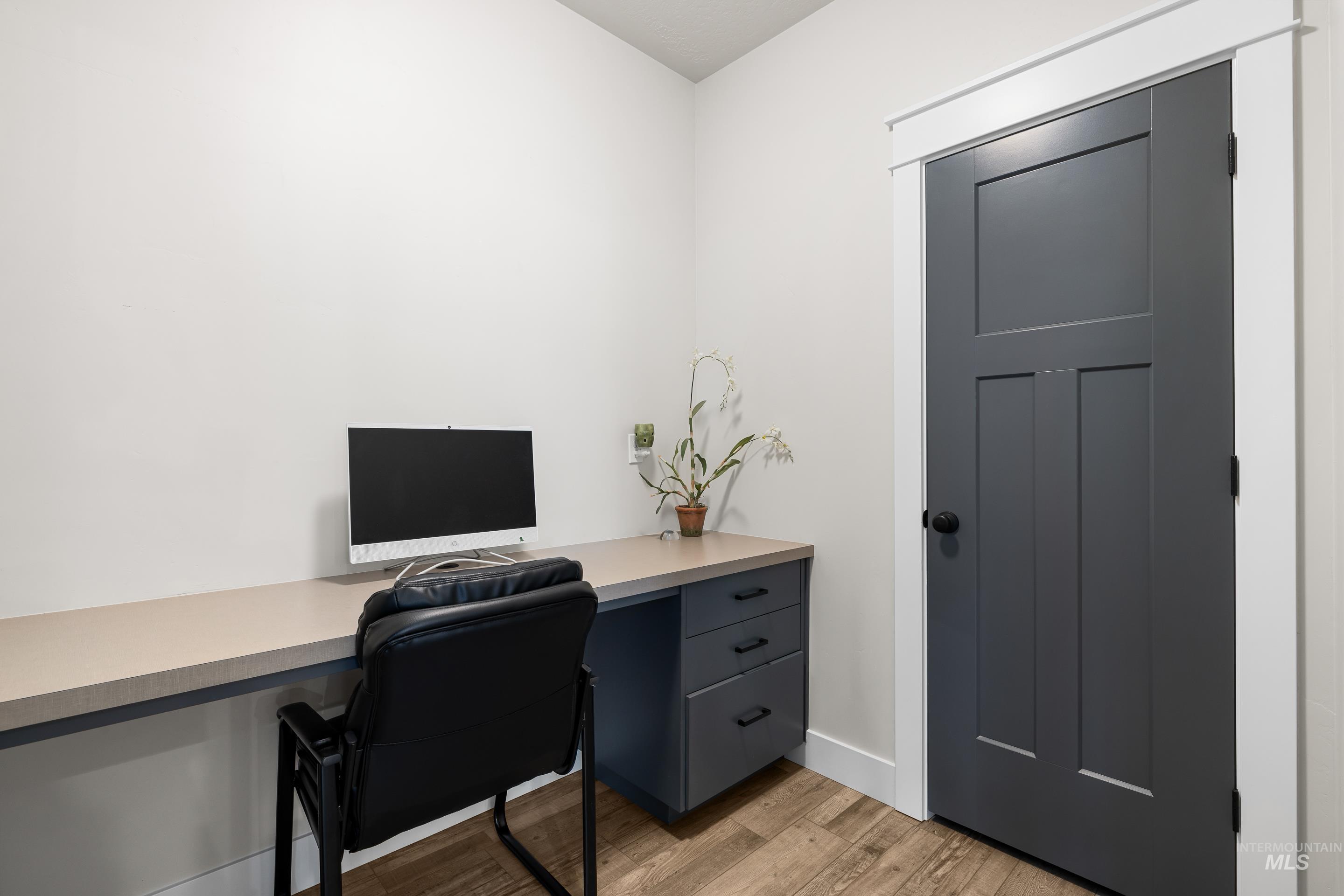 Office area featuring light wood-style floors and baseboards