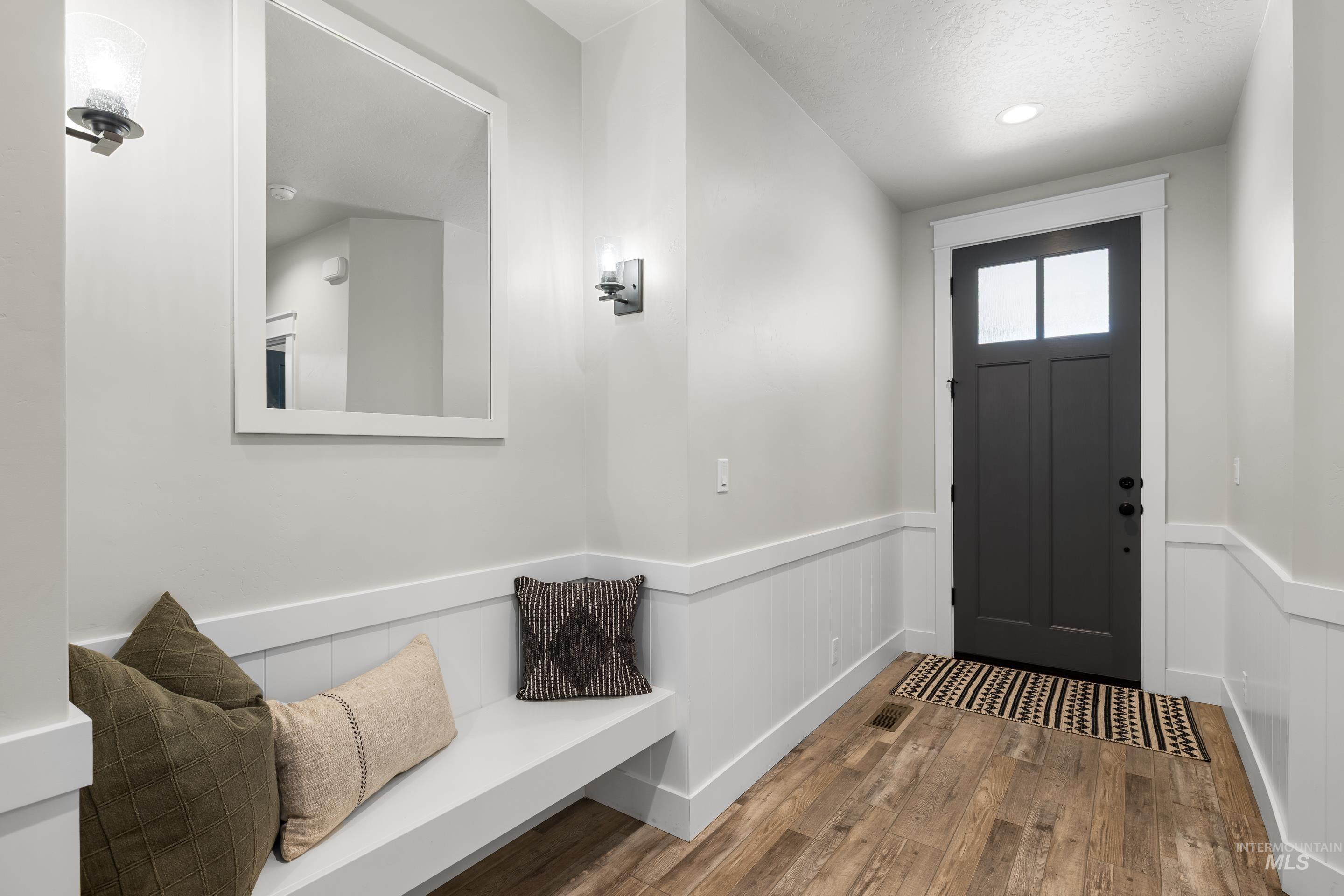 Foyer featuring wood finished floors, wainscoting, and recessed lighting