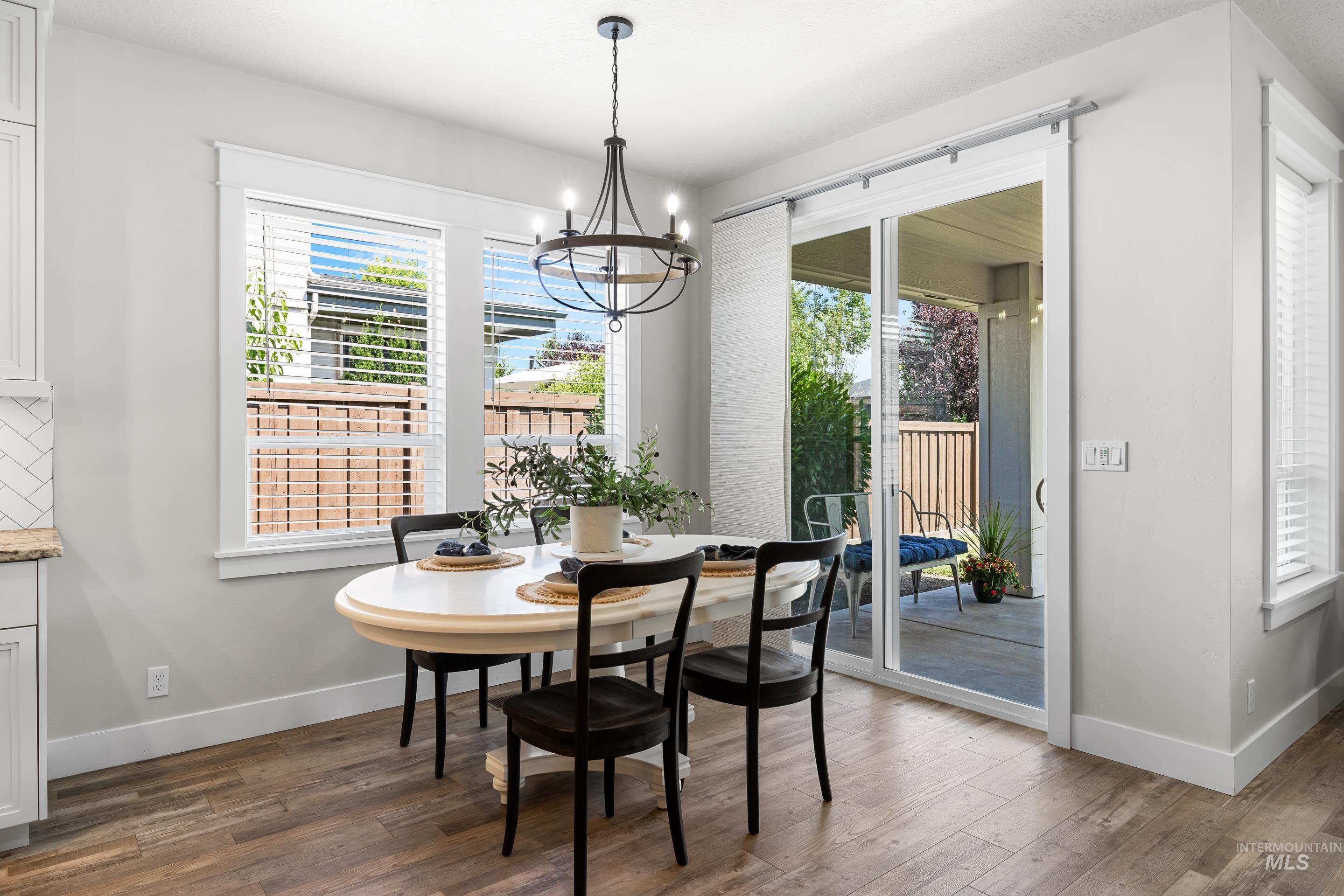 Dining area with a chandelier, plenty of natural light, and wood finished floors