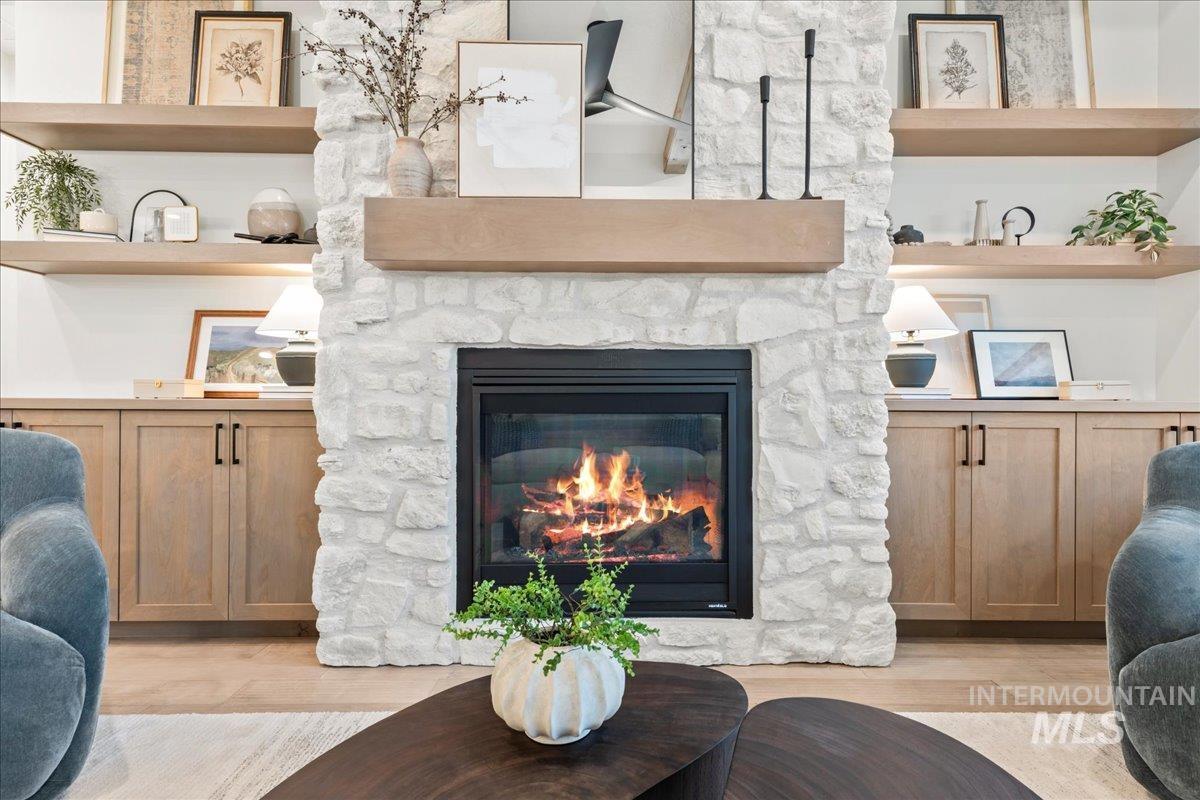 Living area featuring light wood-style flooring, a fireplace, and built in features