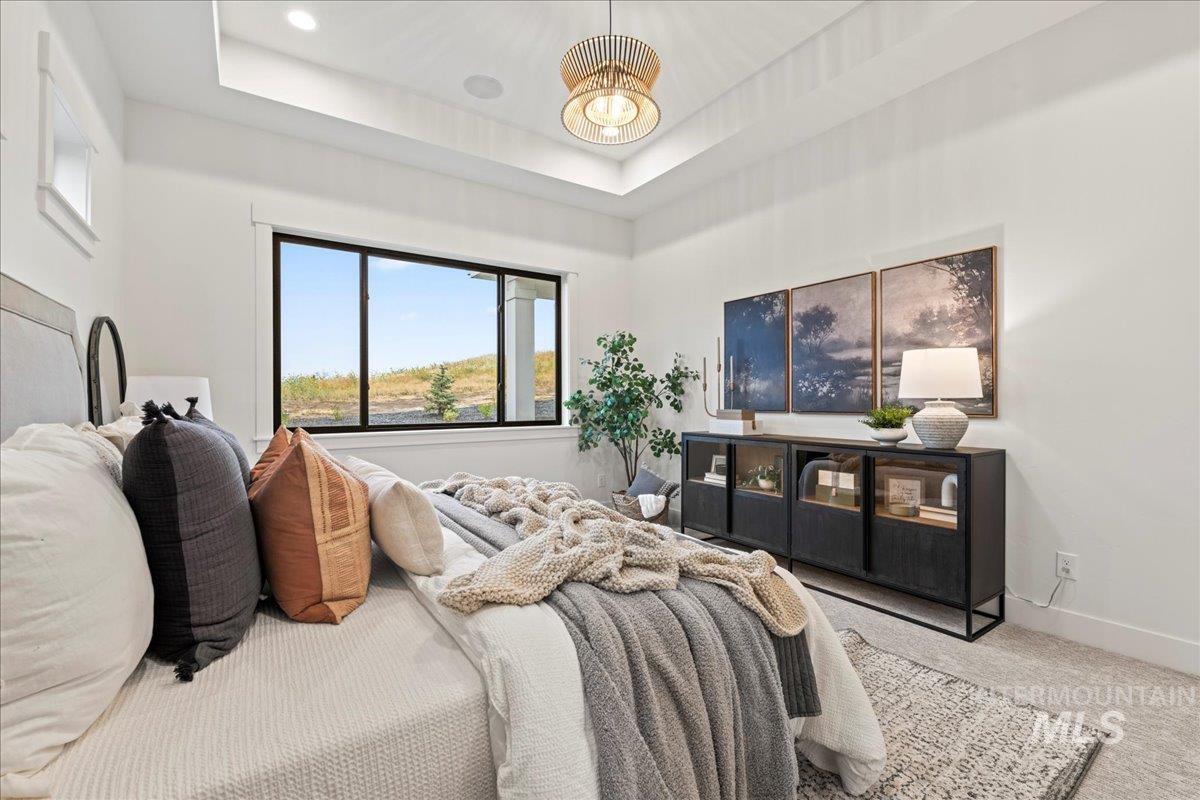 Bedroom featuring a tray ceiling and carpet