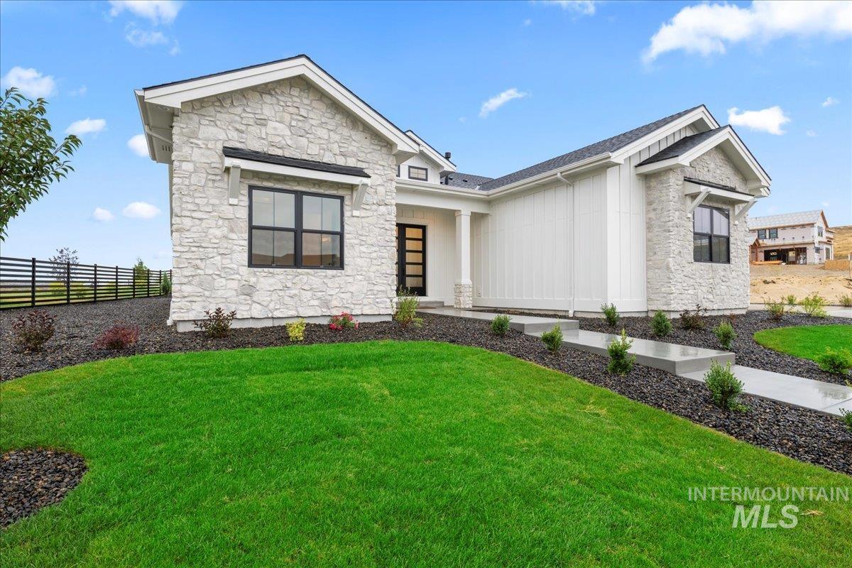 View of front of property featuring stone siding, a porch, and board and batten siding
